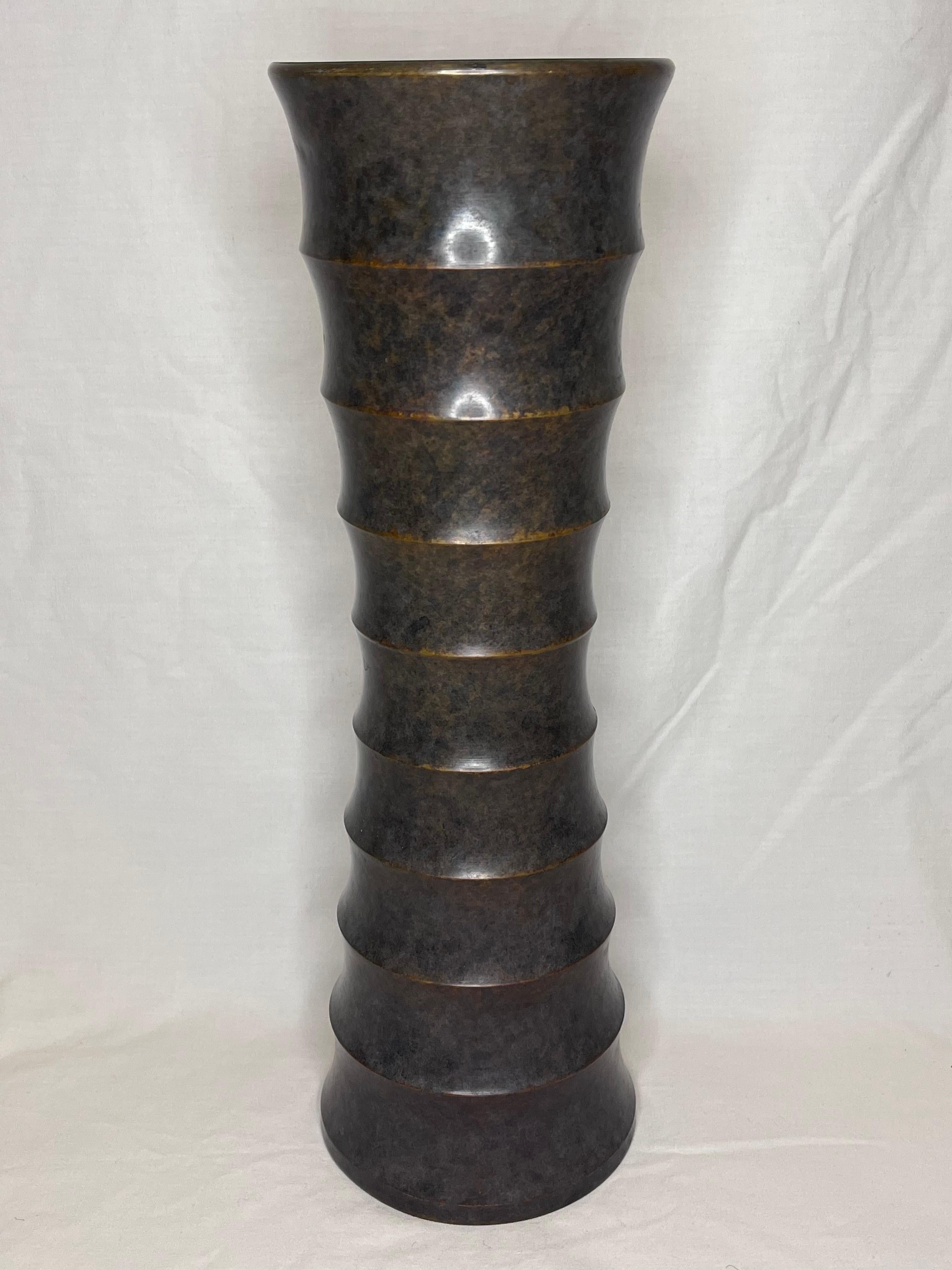 A beautifully hand finished bronze vase with a Brancusi inspired organic modern form. Classical, yet contemporary styling prepares this work of art to be at ease in any interior. The ribbed and tapered silhouette is delicate and powerful all at