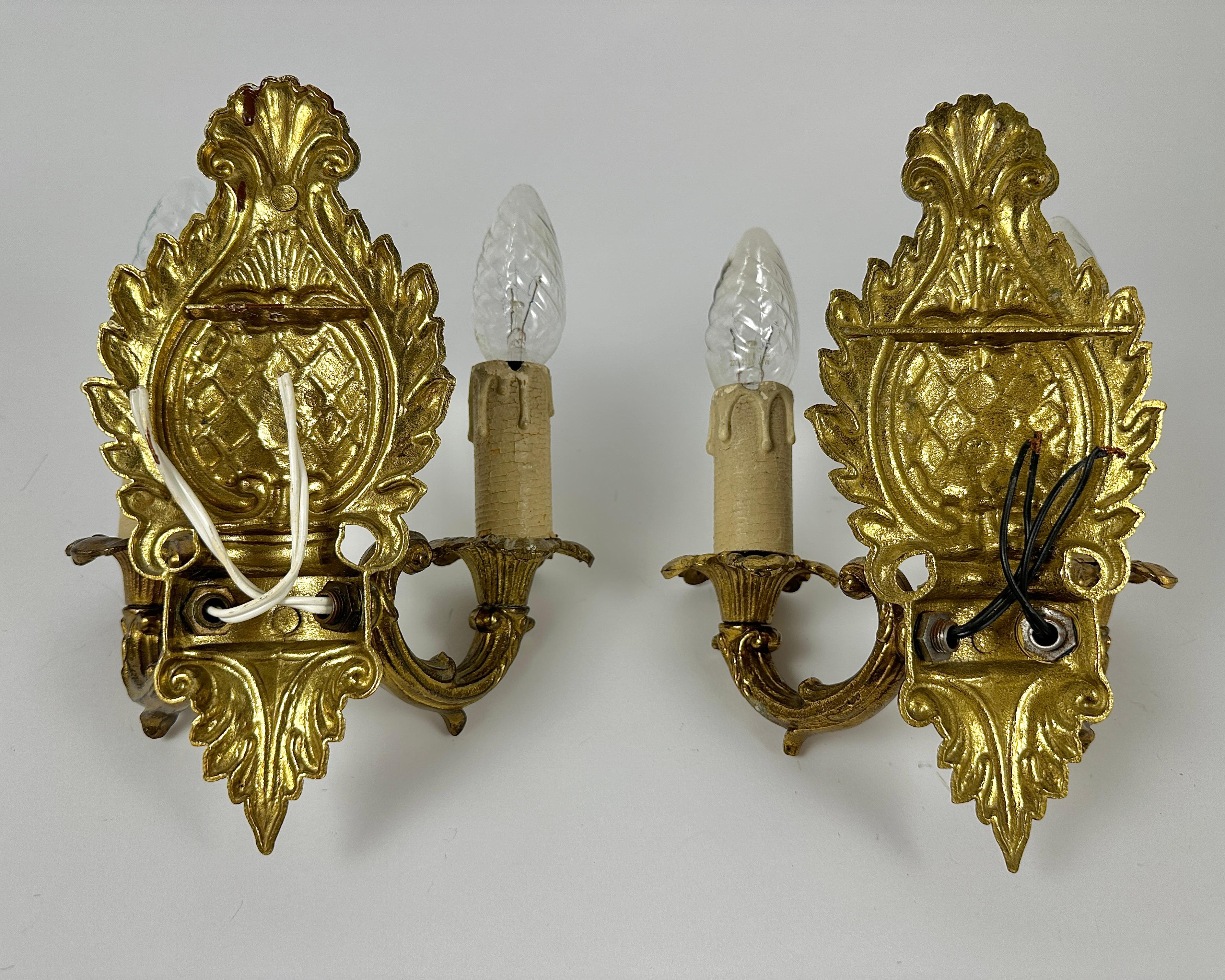 Pair of empire style wall lights manufactured in the 20th century. 

Bronze construction.

Original gilding. The sconces are decorated with acanthus leaves.  

Decorative details made of cast bronze are decorated with three-dimensional patterns of