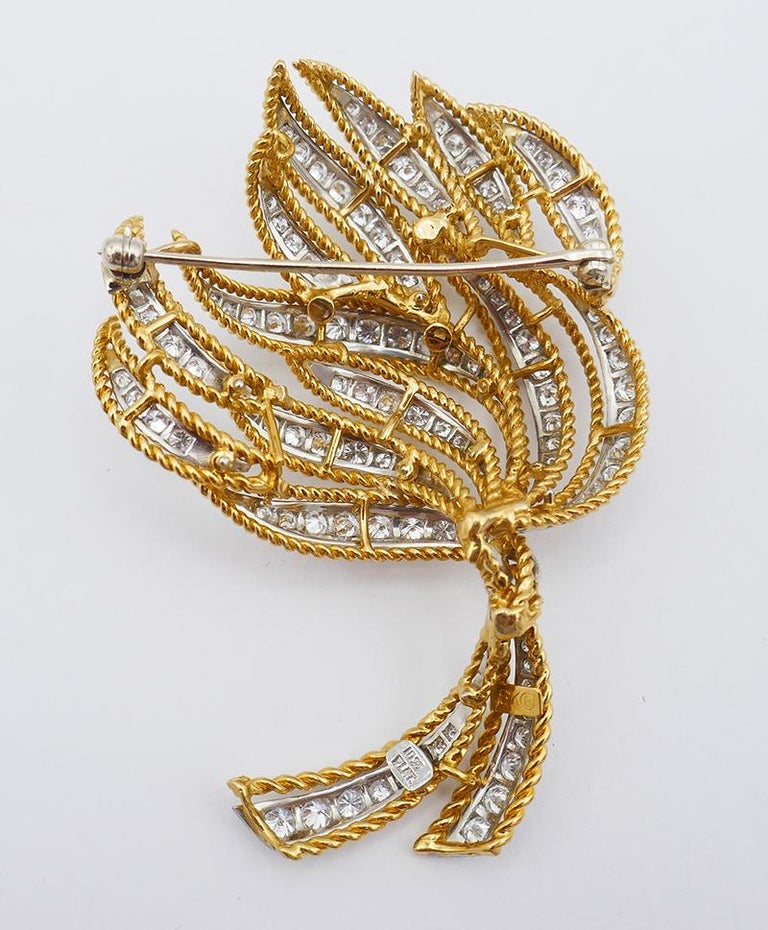         An amazing vintage brooch, made of 18 karat yellow gold and platinum, featuring diamonds.
	The brooch is designed as a stylized bouquet of flowers or a fire torch. It comprises yellow gold open work elements that could be interpreted either