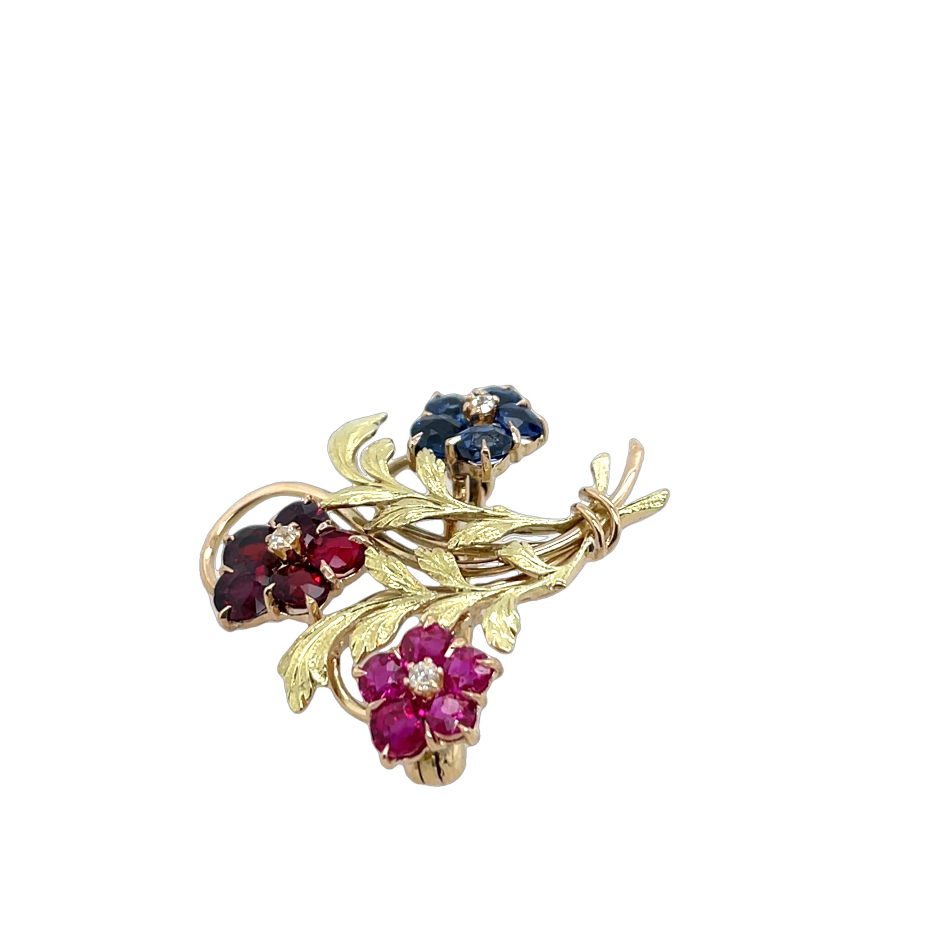 A timeless vintage brooch, exquisitely crafted in 14ct yellow gold, 
set with a dazzling combination of sapphires, diamonds, and rubies. The intricate design showcases the elegance of old-world craftsmanship, with each gemstone carefully placed to