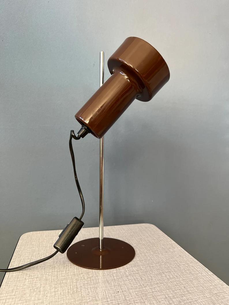 Vintage small brown space age table lamp with adjustable spot. The light can move up and down the base and easily adjusted in position. The lamp requires one E27/26 (standard) lightbulb and currently has an EU plug.

Additional