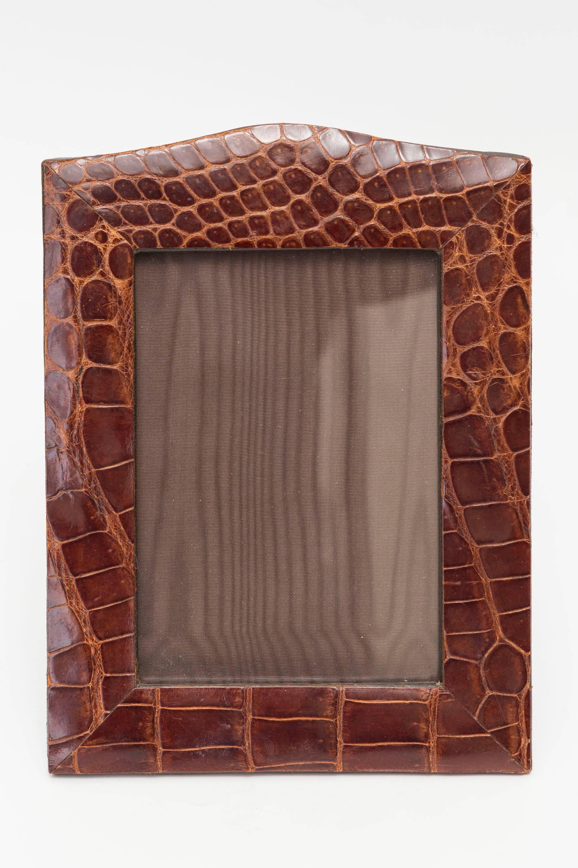 This item is a beautiful vintage brown alligator skin picture frame that has a slight arch top. It holds a photo size 4.25 in x 6.25 in.  