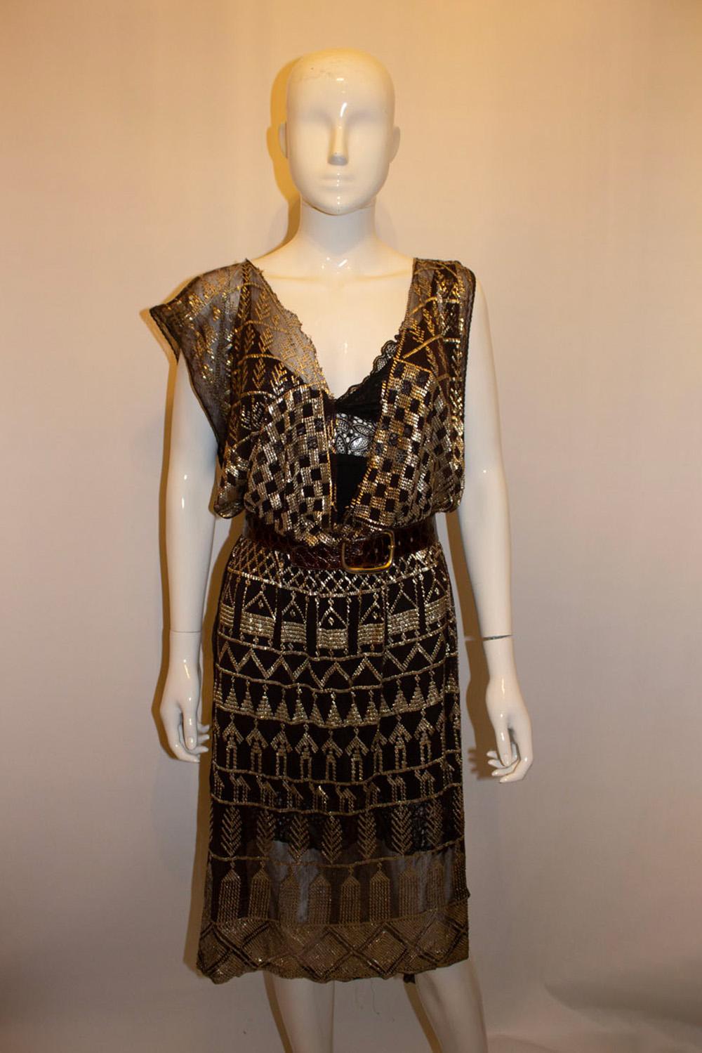 A headturning vintage evening dress . The dress is made of a brown and gold assuit fabric dating from the 1920s. It simply pops over the head and ties with a belt at the waist . In very good condition. 
Measurements: width 36'', length 82''