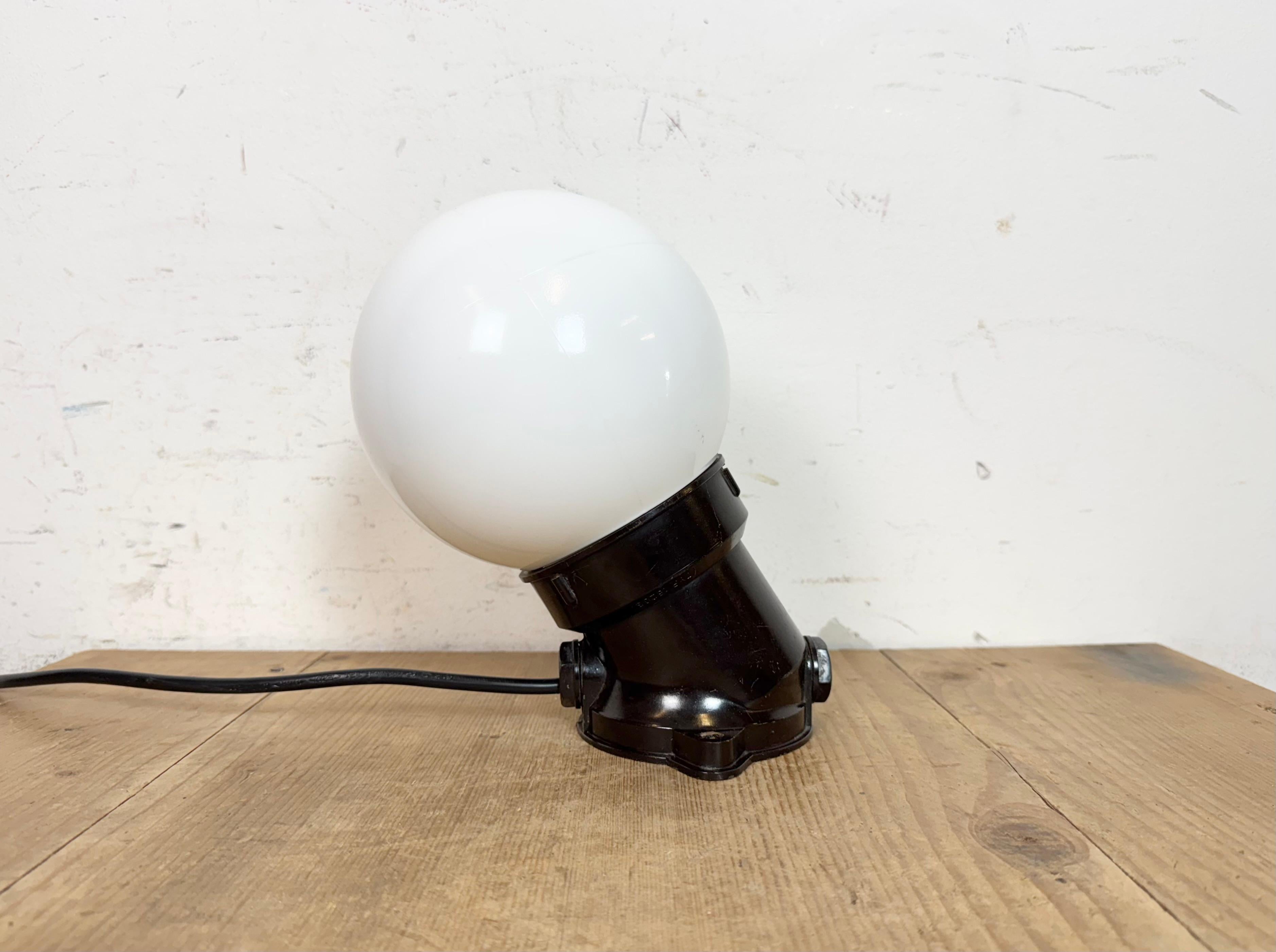 Lampada industriale vintage realizzata nell'ex Cecoslovacchia negli anni '70. Presenta un supporto da parete in bachelite marrone e un coperchio in vetro lattiginoso. L'attacco richiede lampadine E27/E 26 standard. Un nuovo cavo. Il peso della