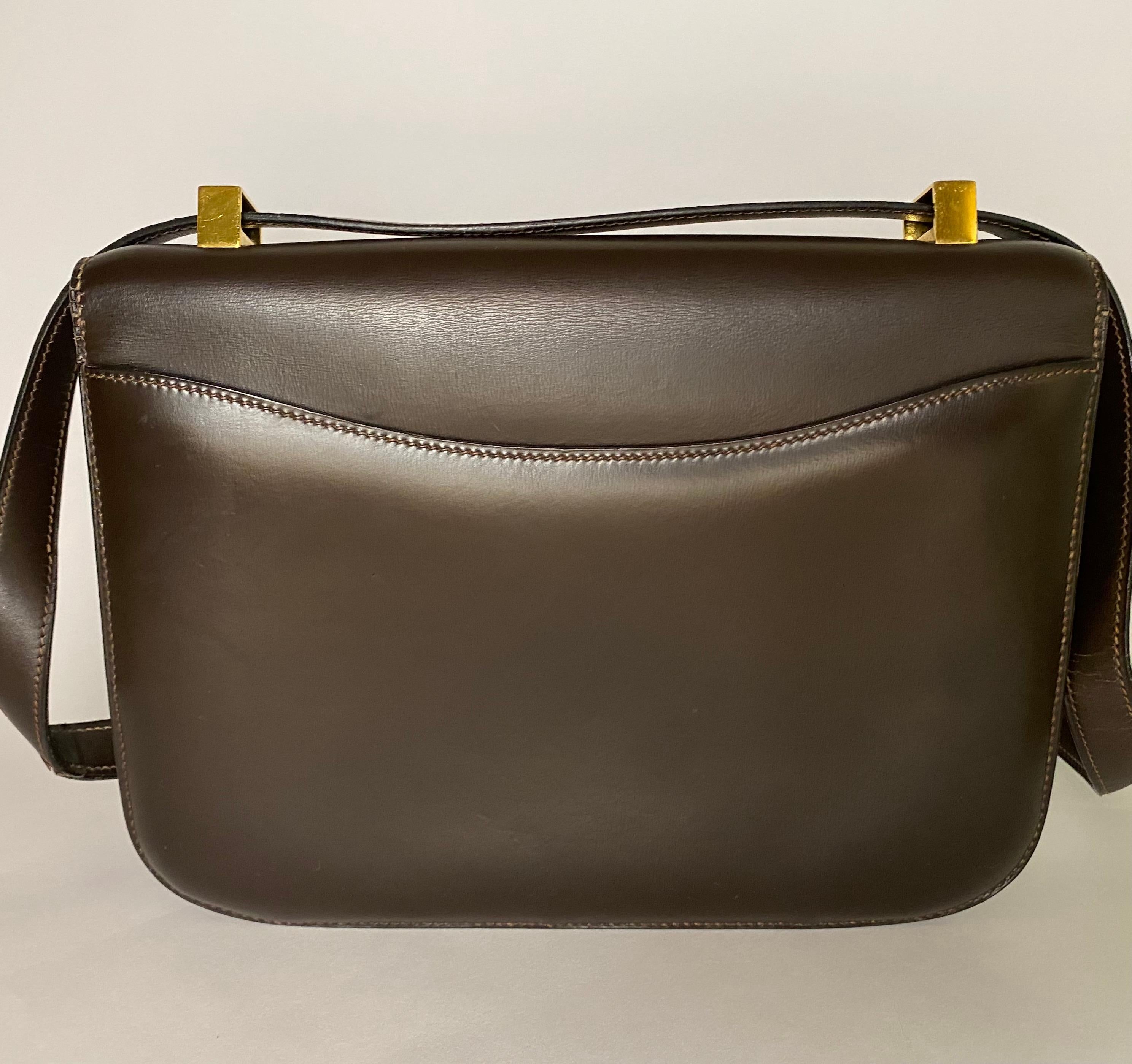 Made with brown box calf leather and gold plated hardware. Produced in 1985. 

Condition: Good used condition.
Exterior: One exterior pocket, light scratching on hardware and leather as to be expected with use, light cracking on strap.
Interior: One
