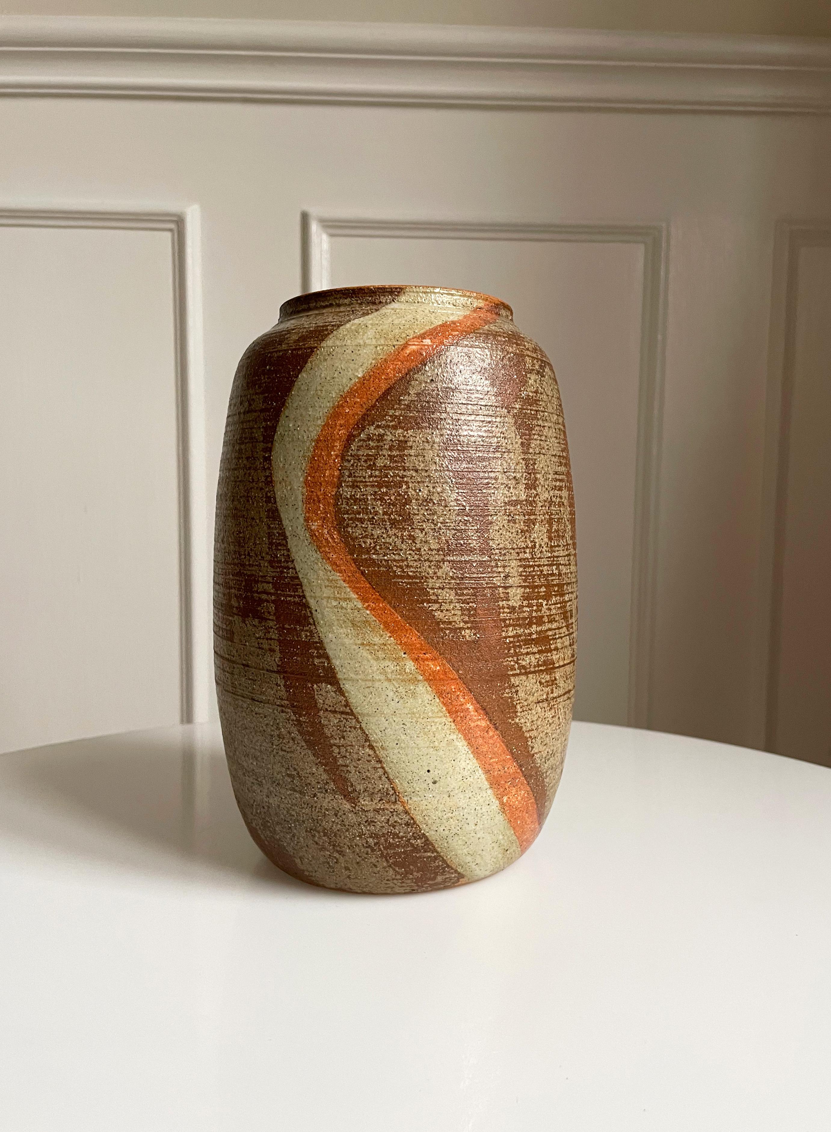 Vintage Danish handmade soft cylinder shaped ceramic vase. Sand and brown colored glaze with cream and burnt orange curved vertical lines. Signed under base. Beautiful vintage condition. 
Denmark, 1980s.
