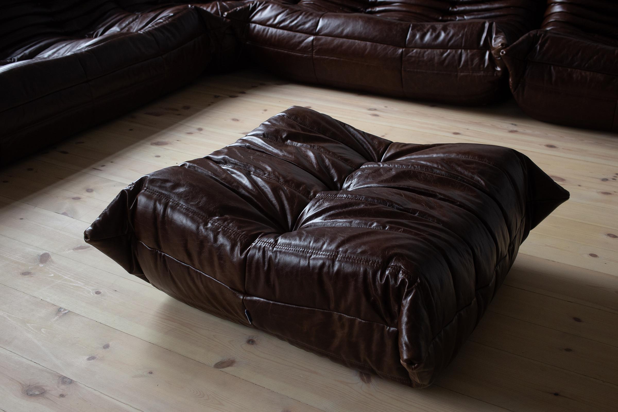 This Togo living room set was designed by Michel Ducaroy in 1973 and was manufactured by Ligne Roset in France circa 1990s-2000s. Each piece has the original Ligne Roset logo and genuine bottom. It has been reupholstered in genuine brown Dubai