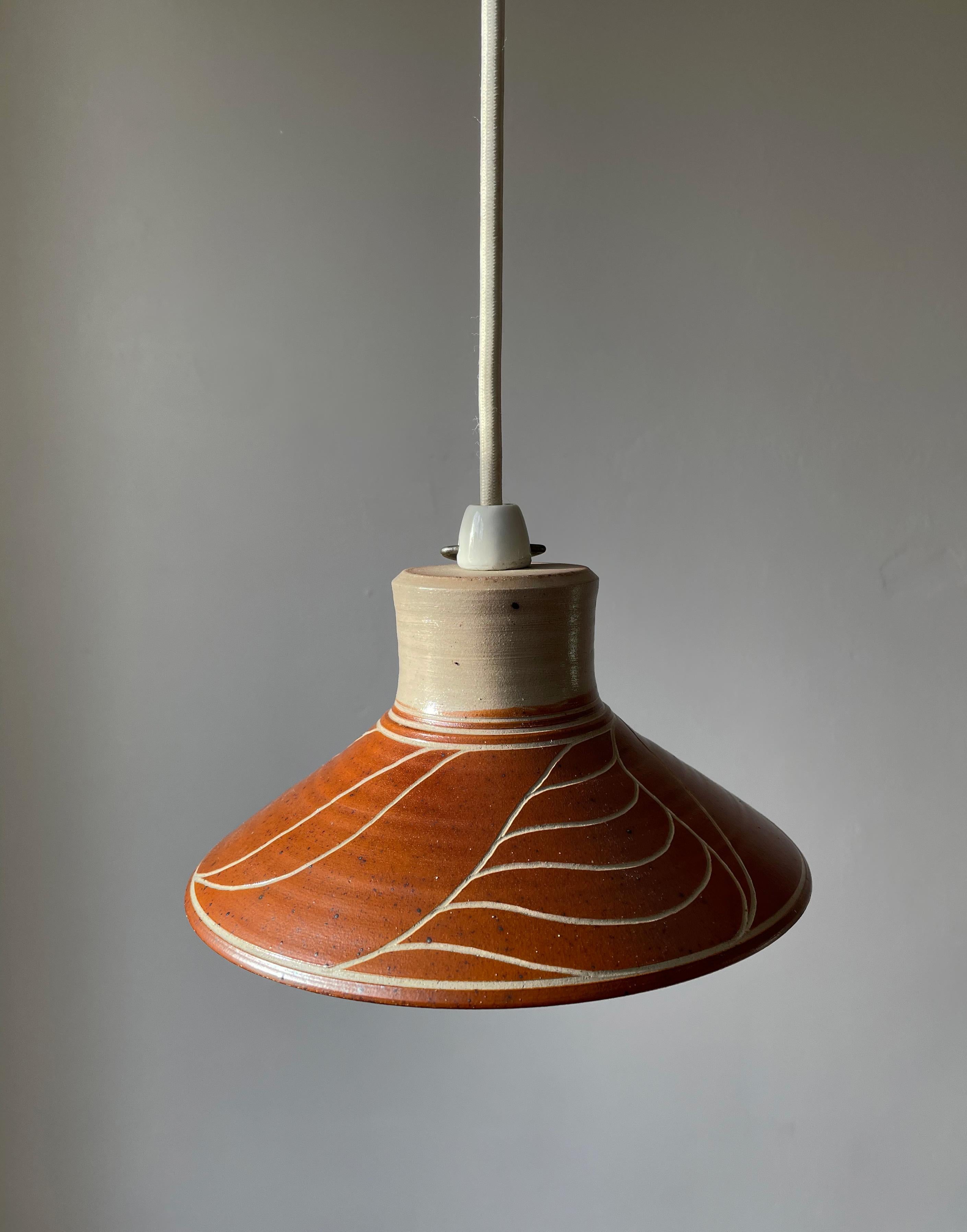 Danish organic modern ceramic pendant with warm brown terracotta glaze and incised leaf-like lined decorations over the beige grey clay with clear glaze. Manufactured in Denmark in the late 1970s. Beautiful vintage condition. Rewired with white