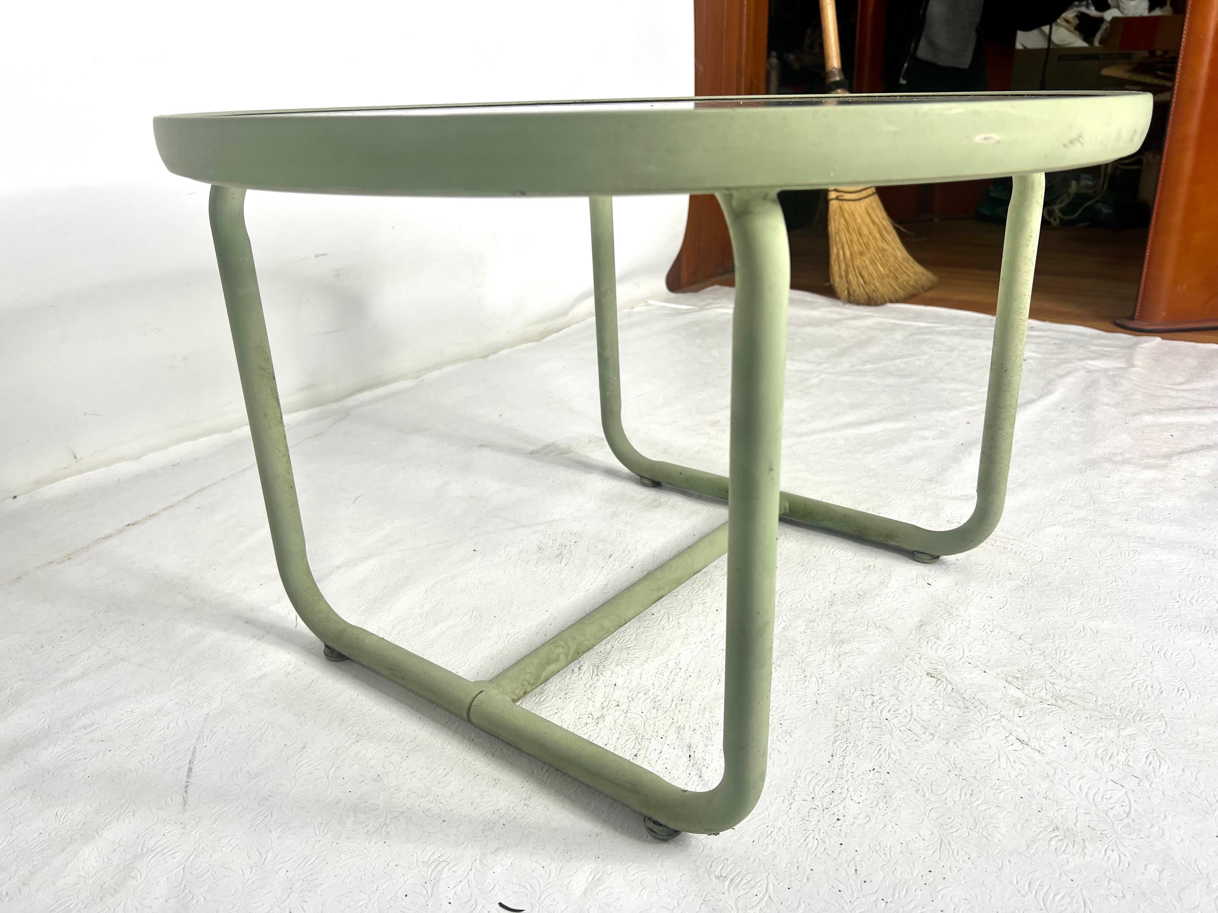Very nice vintage aluminum and glass side table made by brown Jordan in a pale green. The table does sit lower to the ground.