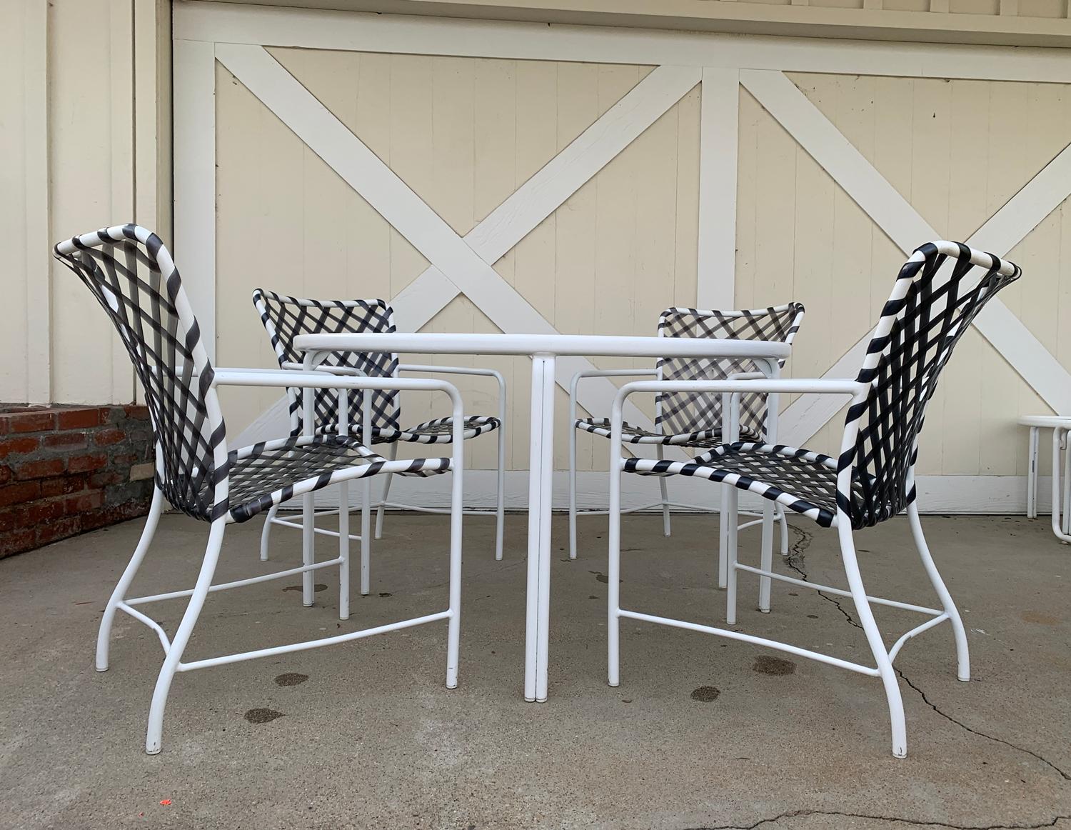 Vintage patio set comprising of 1 round table and 4 armchairs designed and manufactured by Brown Jordan from the Tamiami Collection.
The set is in very good condition, with normal wear which includes nicks and scuffs on metal, the vinyl straps are