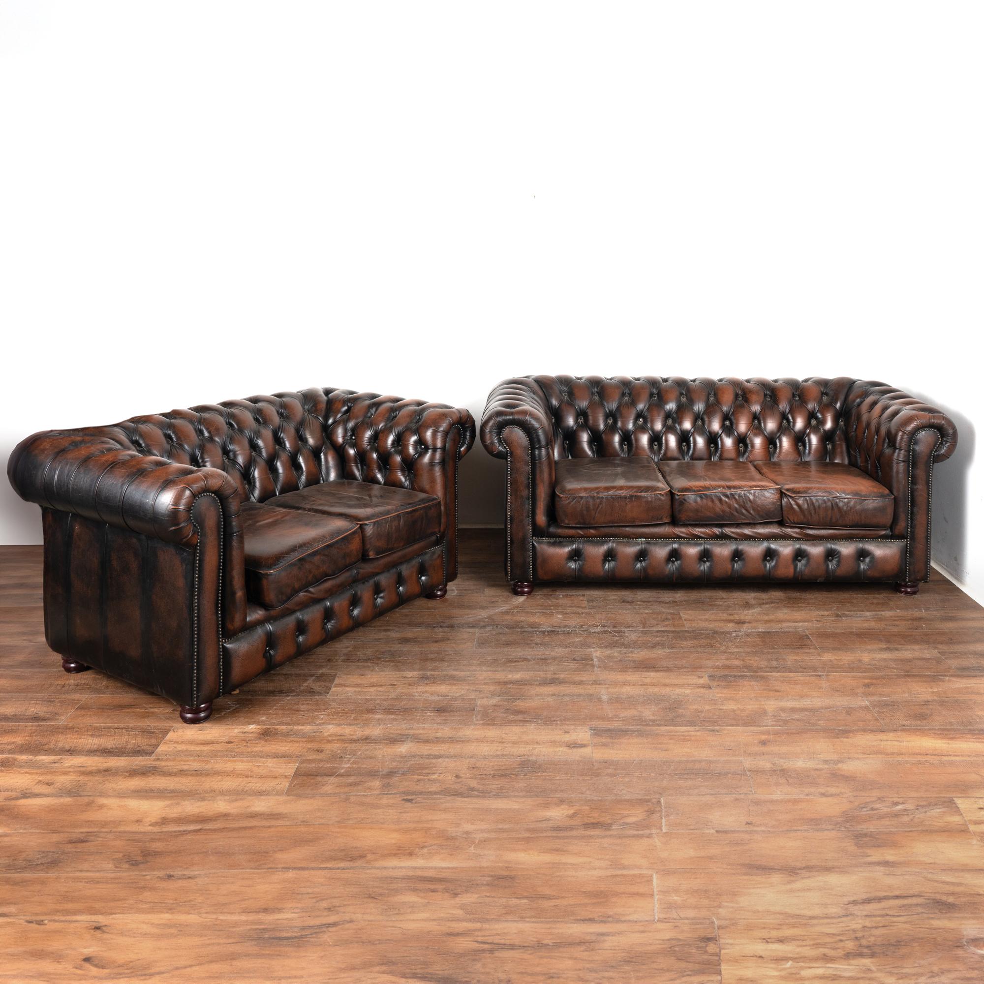 Loaded with character, this two seat sofa and three seat sofa packs a vintage punch with the tufted back of the classic Chesterfield look with self covered buttons, heavy rolled arms nailhead trim and bun feet.
The vintage brown leather is mottled