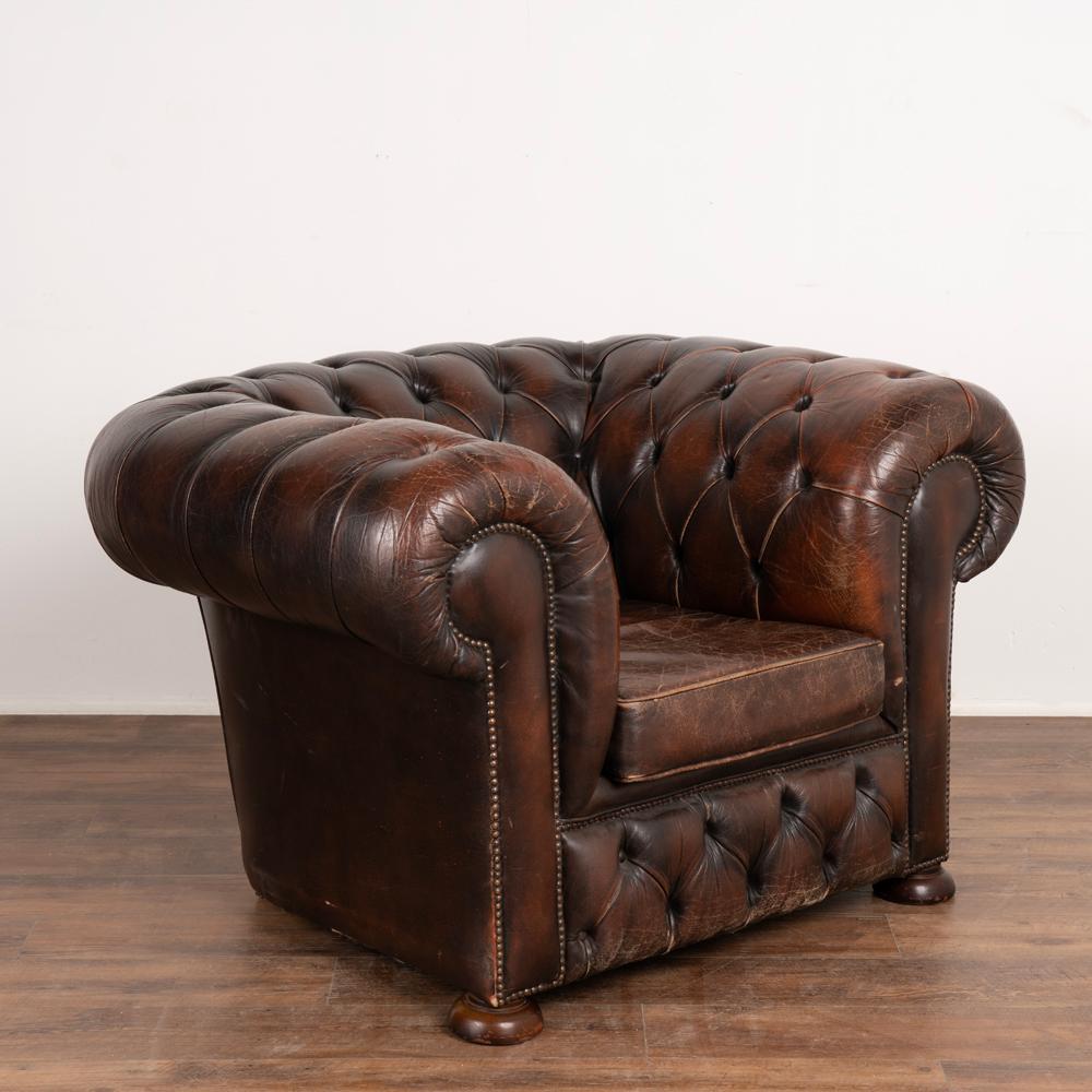 Vintage leather chesterfield style club arm chair.
Upholstered in studded button-stitched leather, loose seat cushion.
Sold in original vintage condition with wear, scuffs, scratches, creases, crackled/distress to leather resulting in aged