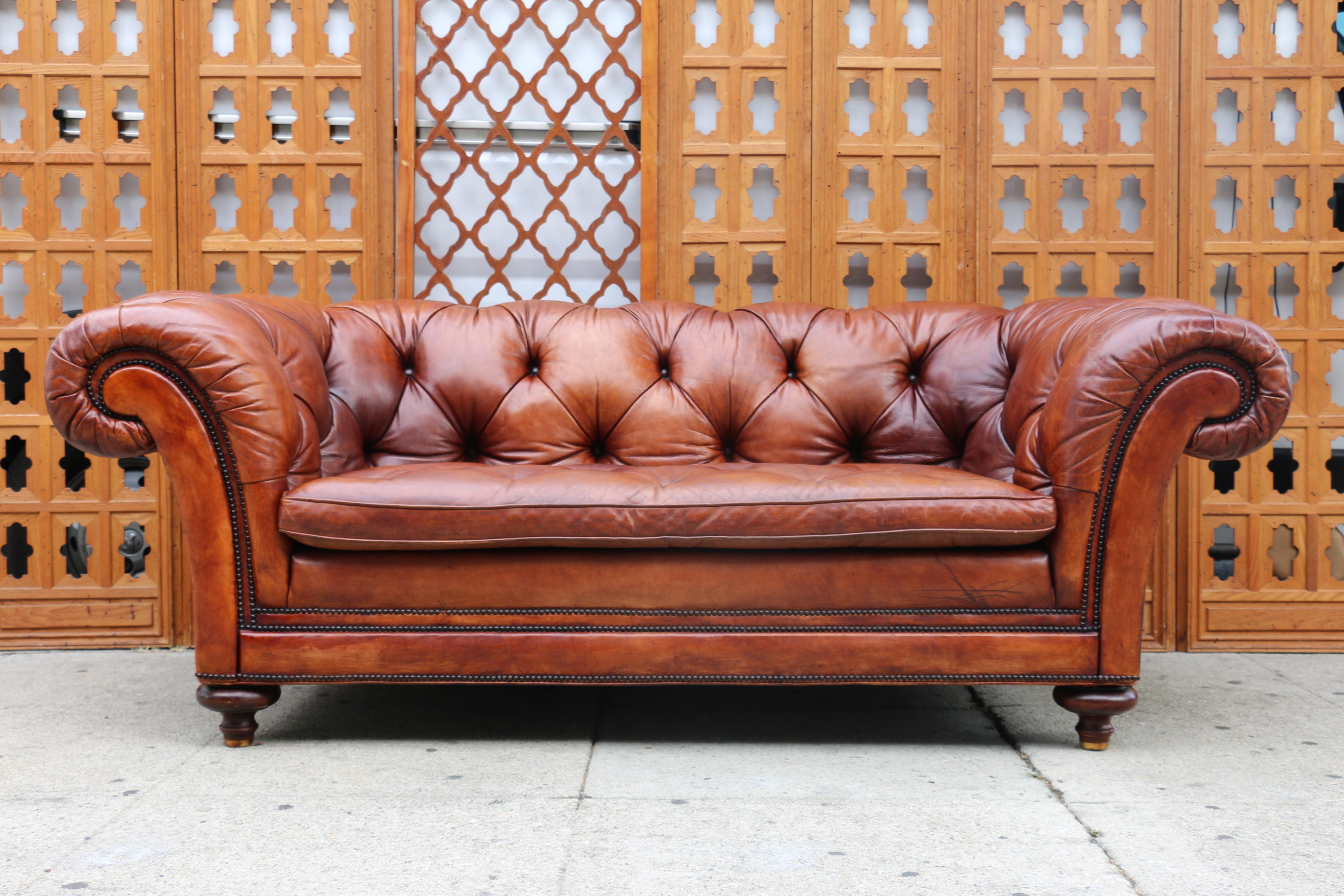 Wunderschönes zeitloses Chesterfield-Sofa von Baker Furniture, CIRCA 1950er Jahre. Dieses Sofa ist aus originalem Leder mit getufteter Rückenlehne und Sitzfläche (die Unterseiten sind gut mit dem Sofa verbunden). Er hat verschnörkelte Armlehnen mit