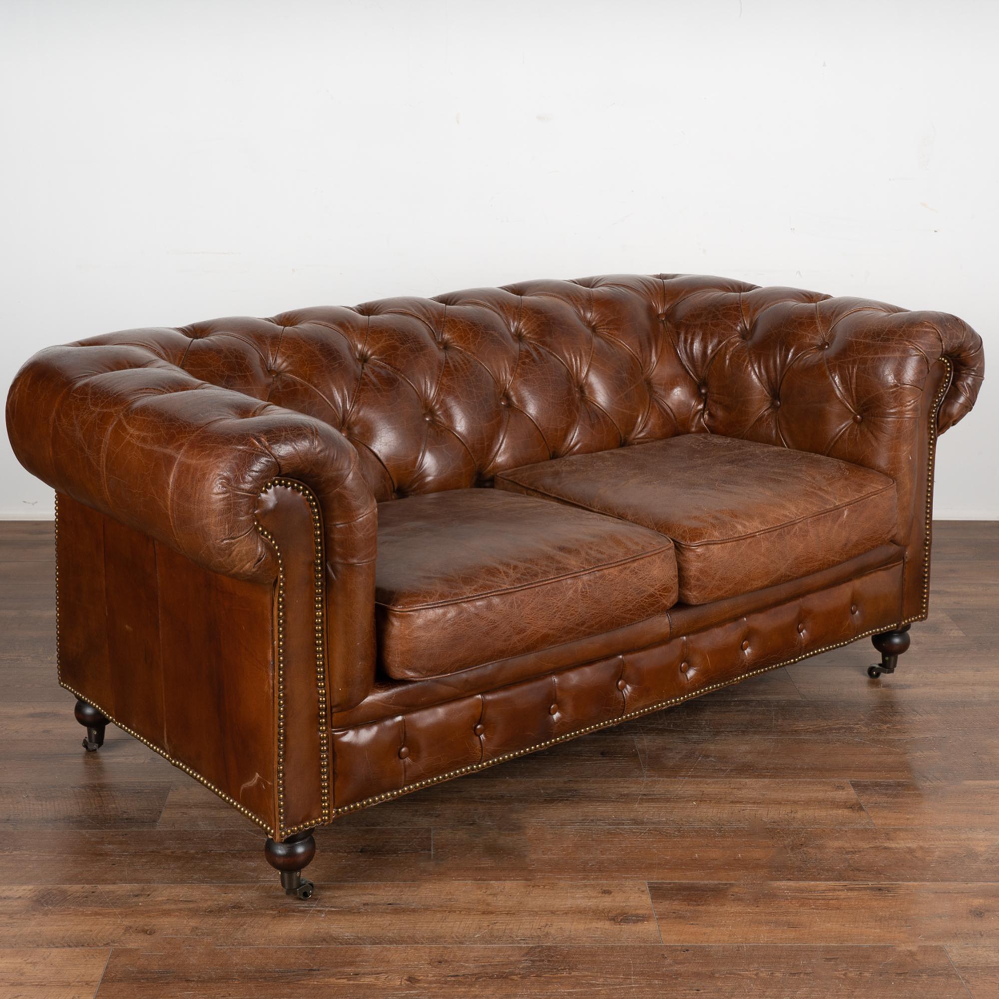 The rich brown vintage leather captures your attention in this wonderful Chesterfield loveseat or 