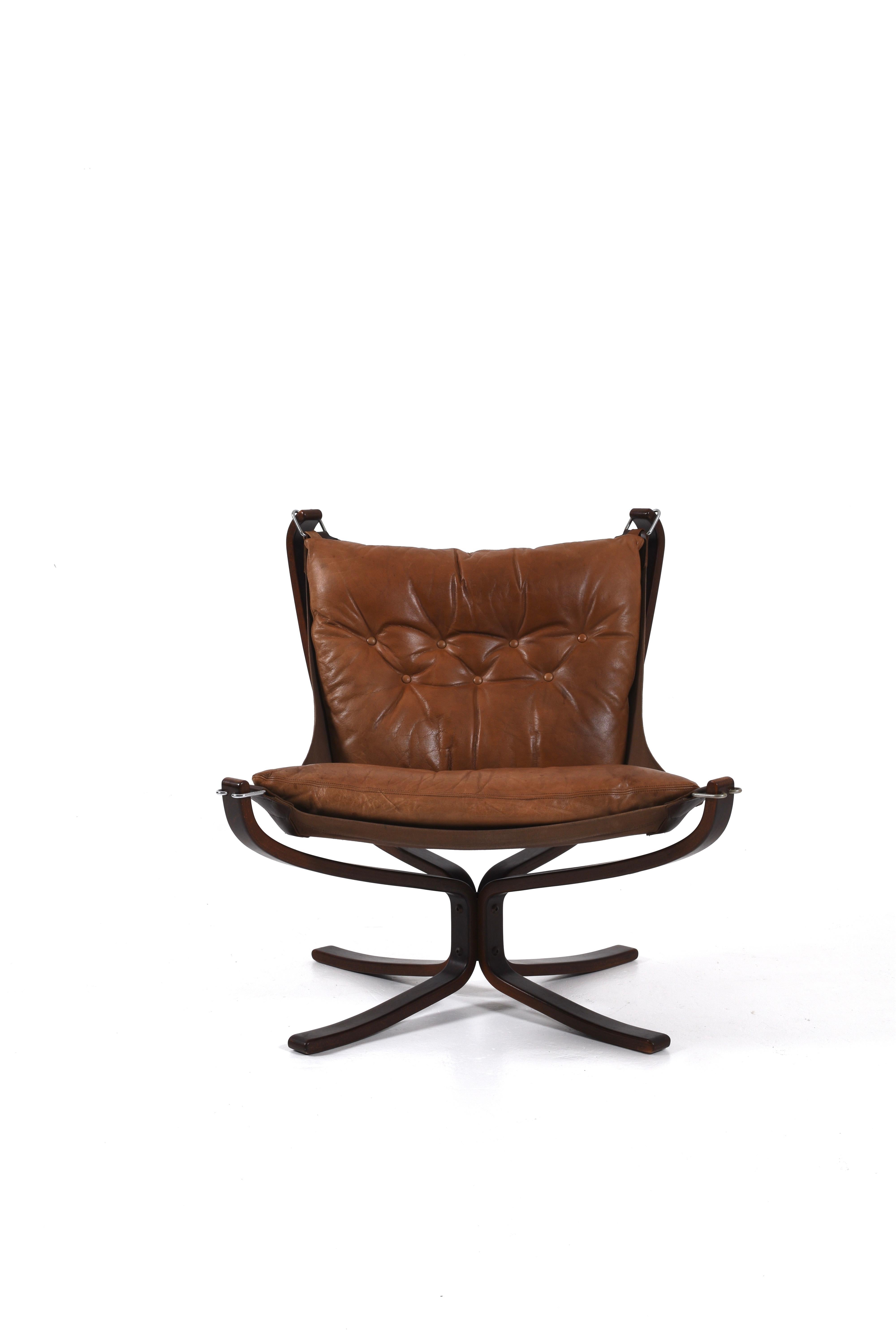 Iconic 1970s Falcon lounge chair designed by Sigurd Ressell for Vatne Møbler. Featuring a sleek bentwood frame, chrome hardware and original brown leather cushions with beautiful patina. A timeless piece of Scandinavian modern design. 

We currently