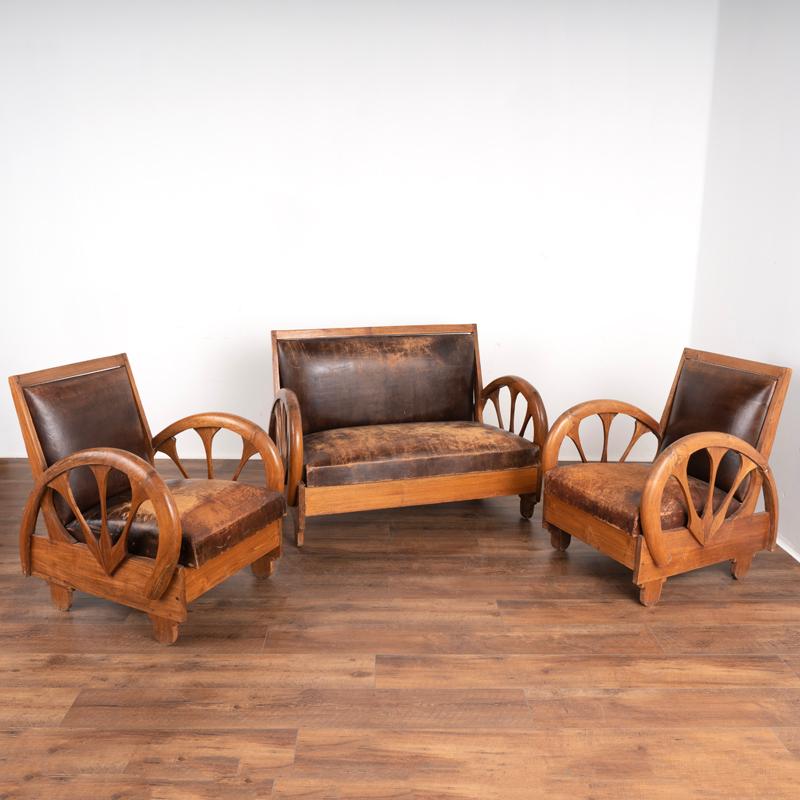 This handsome loveseat and pair of arm chairs are a great find for one searching for an authentic vintage leather set. The rich brown leather is perfectly patina'd from years of use revealed in the character of the distressed leather seats. The