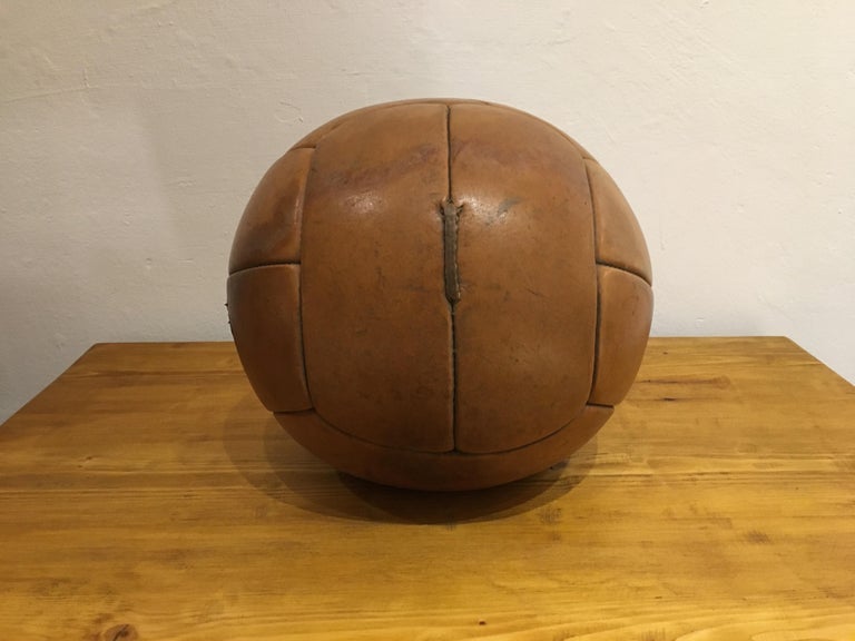 This medicine ball comes from the stock of an old Czech gymnasium. Made in the 1930s. Patina consistent with age and use. Cleaned and treated with a special leather care. Weight: 3kg. Measures: Diameter 10.2 inch.
 