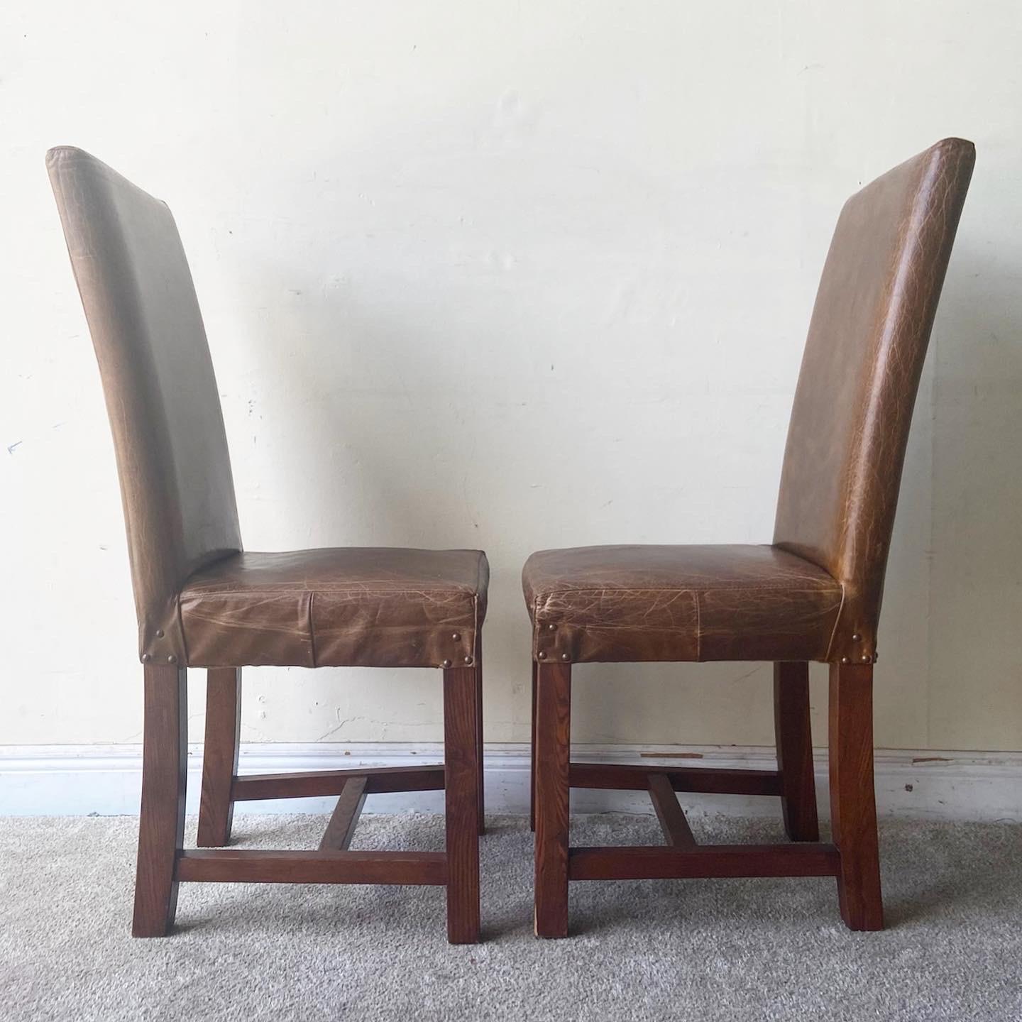 Amazing pair of vintage parsons dining chairs. Features a leather seat and backrest.
 