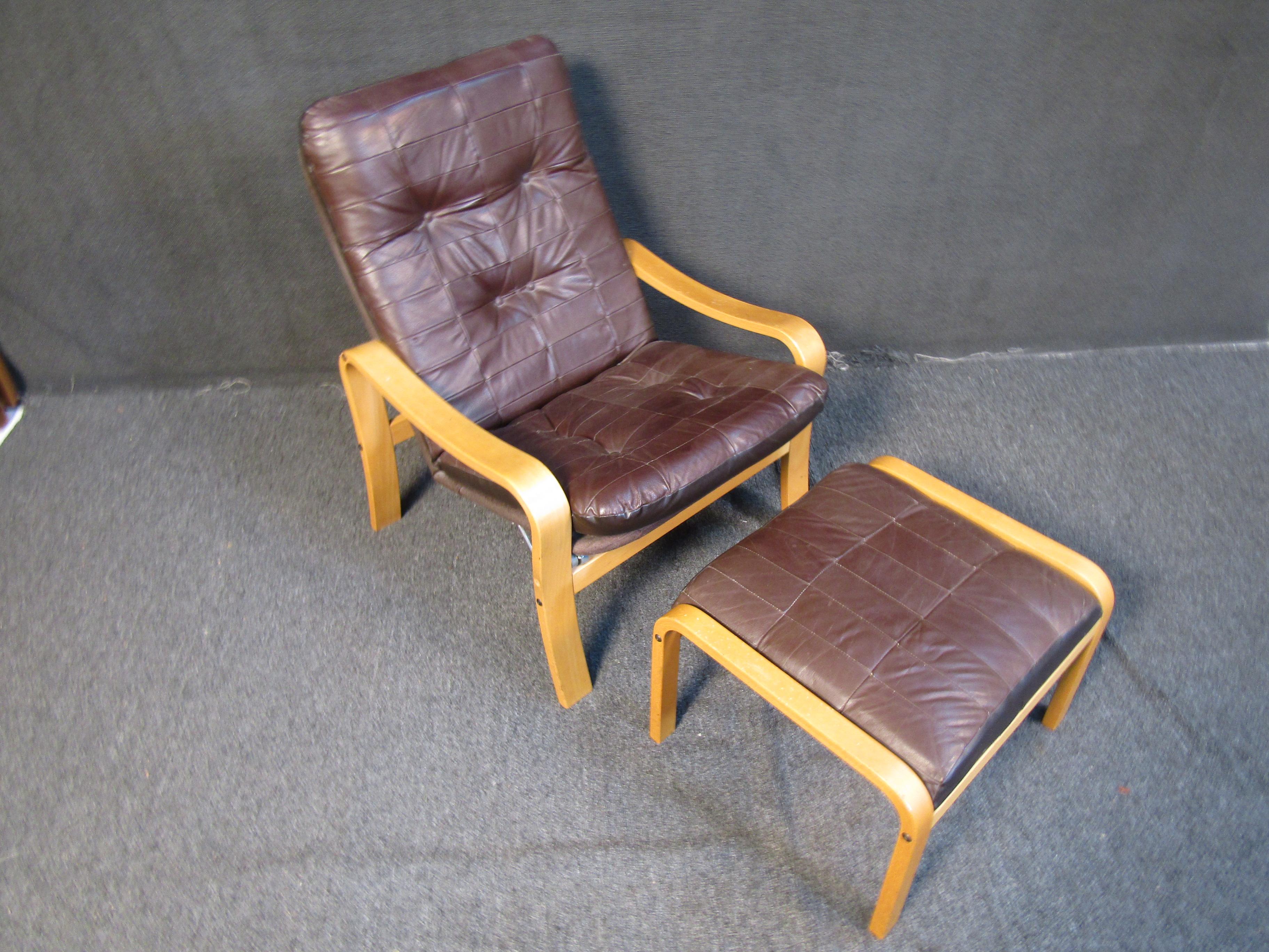 This recliner and ottoman set features a combination of rich brown leather and a light wooden frame for a unique look. Please confirm item location with seller (NY/NJ).