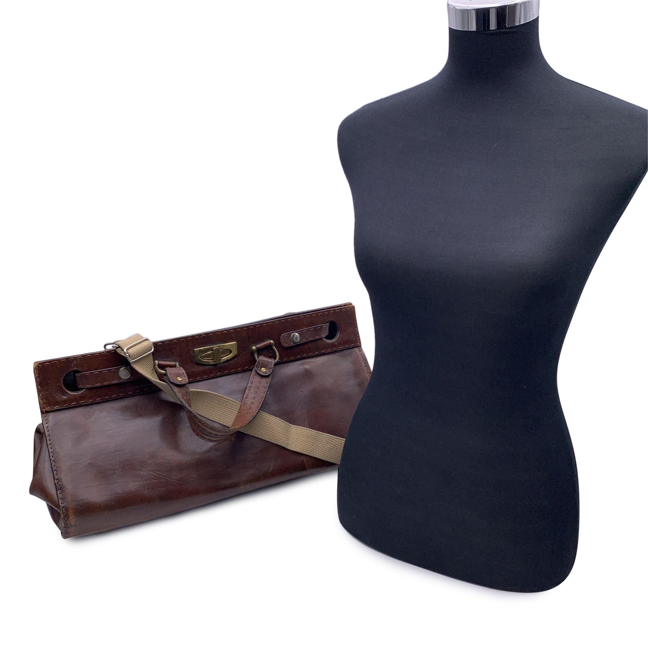 Vintage satchel travel bag in brown genuine leather. Double top handles, removable and adjustable shoulder strap. Front turn lock closure. Beige leather lining. 1 side zip pocket inside. Condition C - FAIR Many scratches on elather due to normal