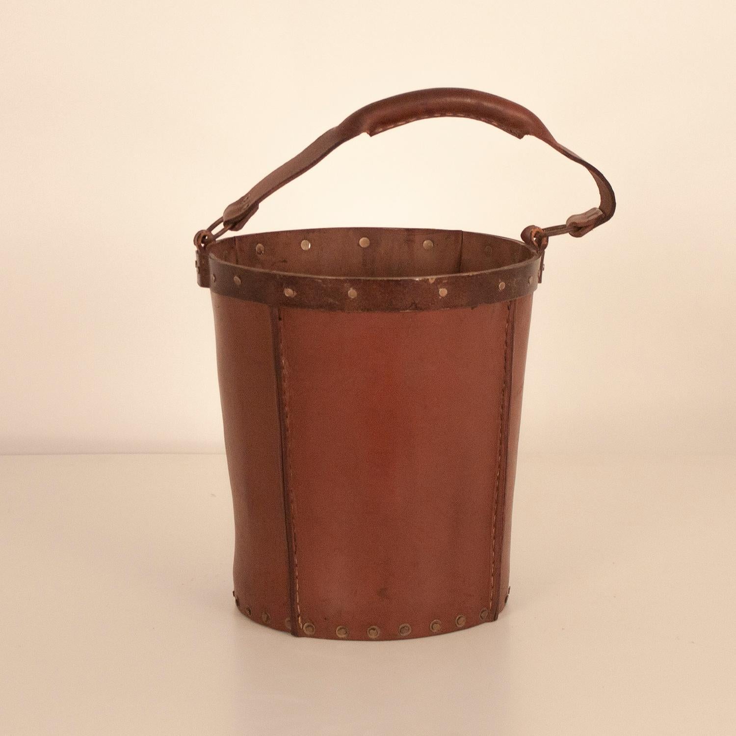 Vintage brown leather waste basket
Made from brown leather with golden metal embellishments.
Produced by Valenti, Spain, circa 1970.