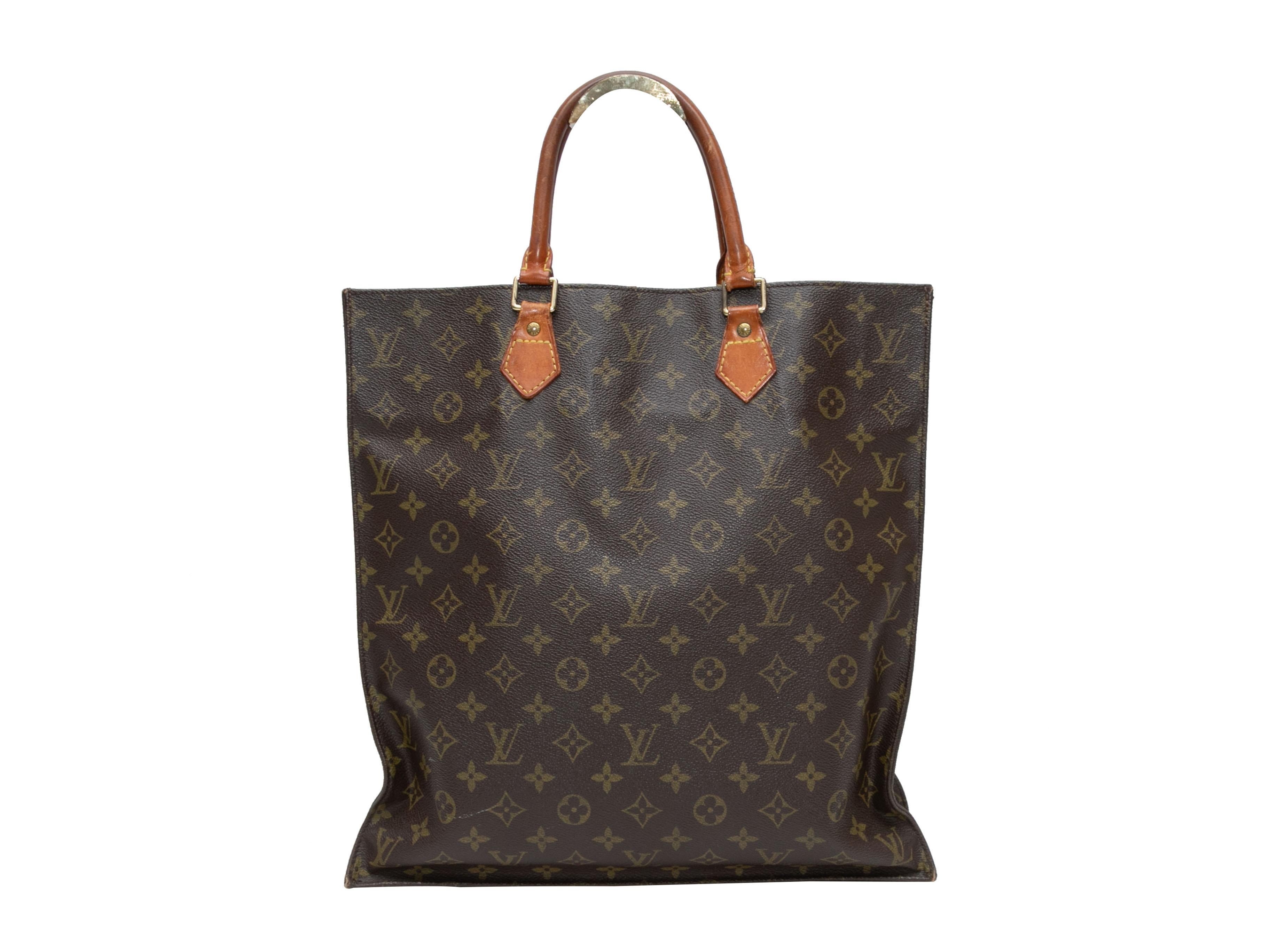 Vintage Brown Louis Vuitton 1980s Sac Plat Bag. The Sac Plat Bag features a monogram coated canvas body, leather trim, gold-tone hardware, dual rolled top handles, and optional crossbody strap. 14.5