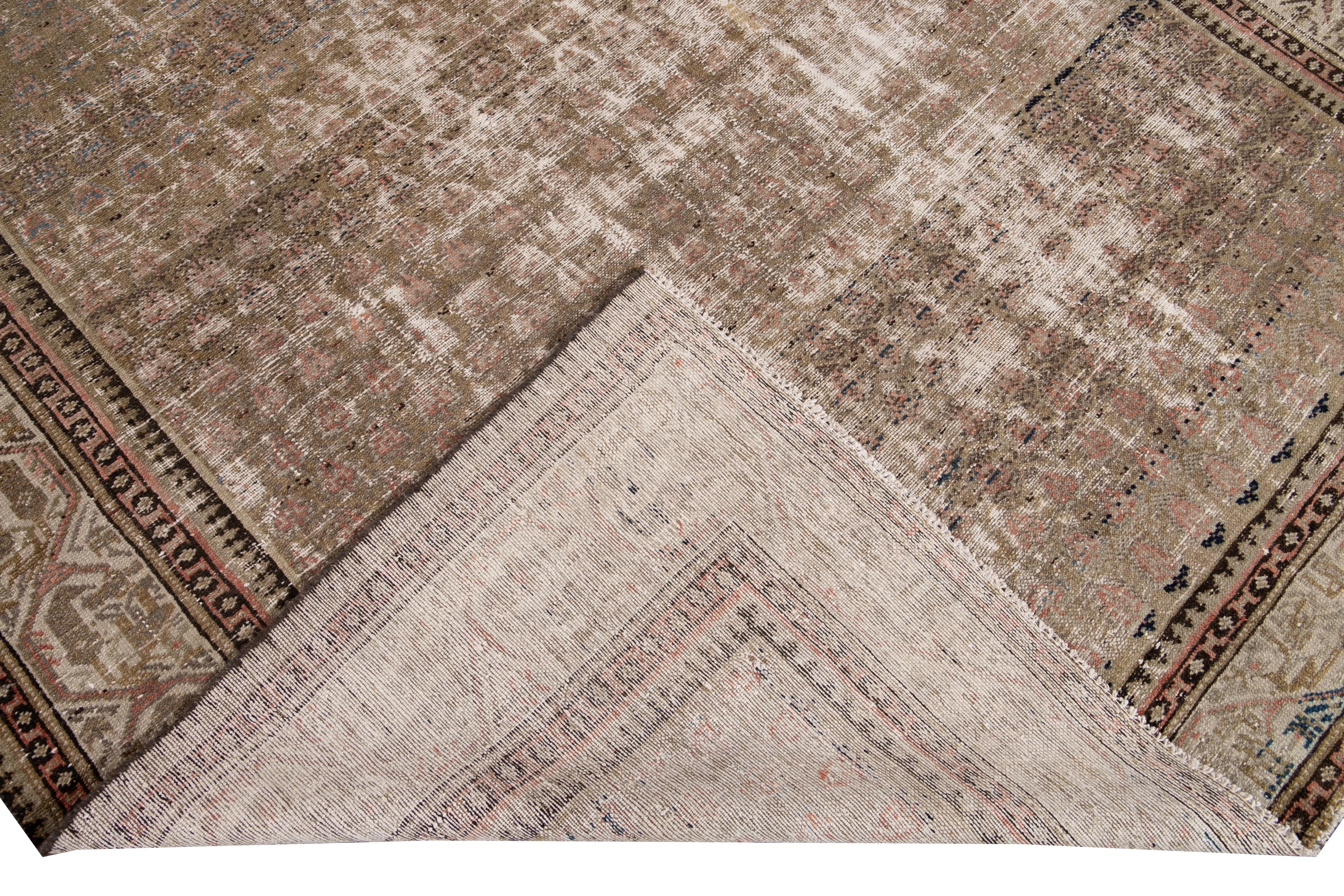 Beautiful vintage Malayer hand knotted wool rug with a brown field. This Malayer piece has beige, blue, and pink accents in an all-over geometric shabby chic design.

This rug measures: 6'5