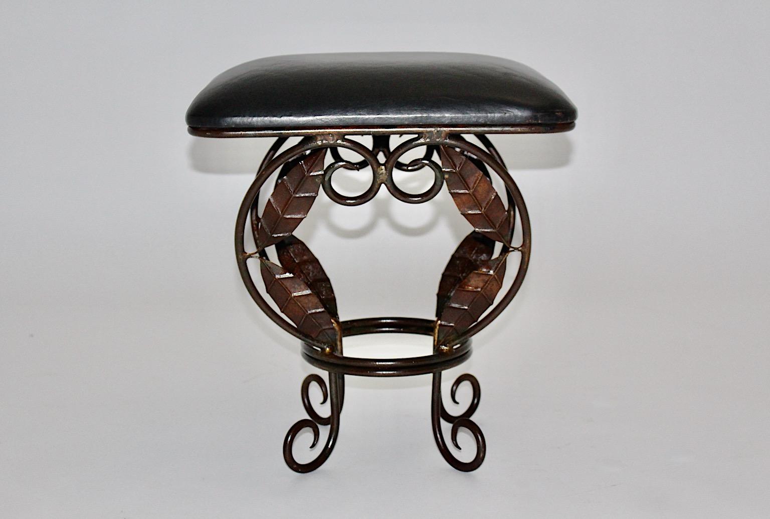 Brown vintage Hollywood Regency style metal stool from iron base with black leather seat designed 1970s, France.
The base demonstrates stunning leaves and ornaments, while the seat is covered with black leather.
The vintage condition is very good