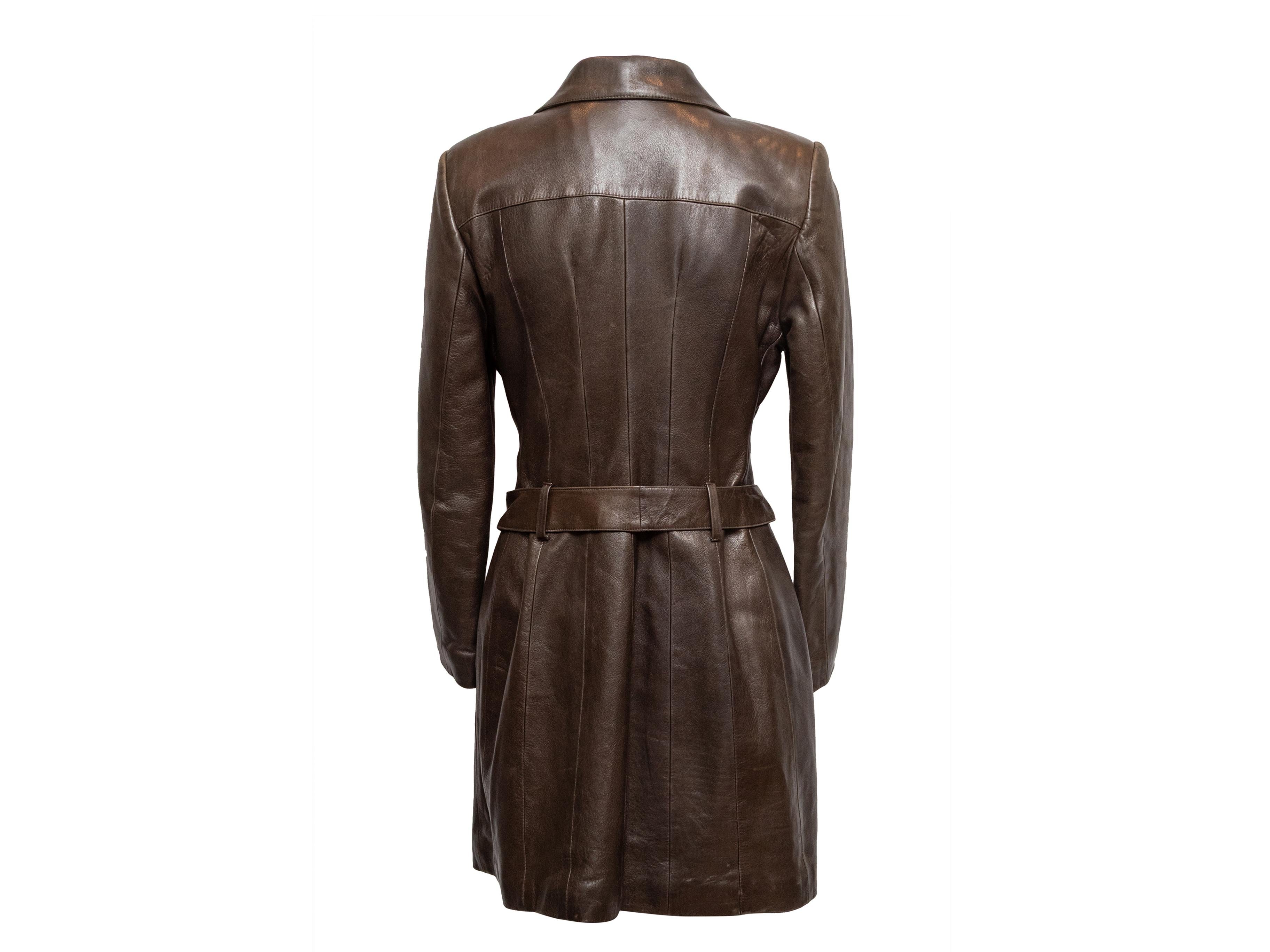 Vintage brown belted leather coat by Prada. Pointed collar. Dual flap pockets at bust. Button closures at center front. 33