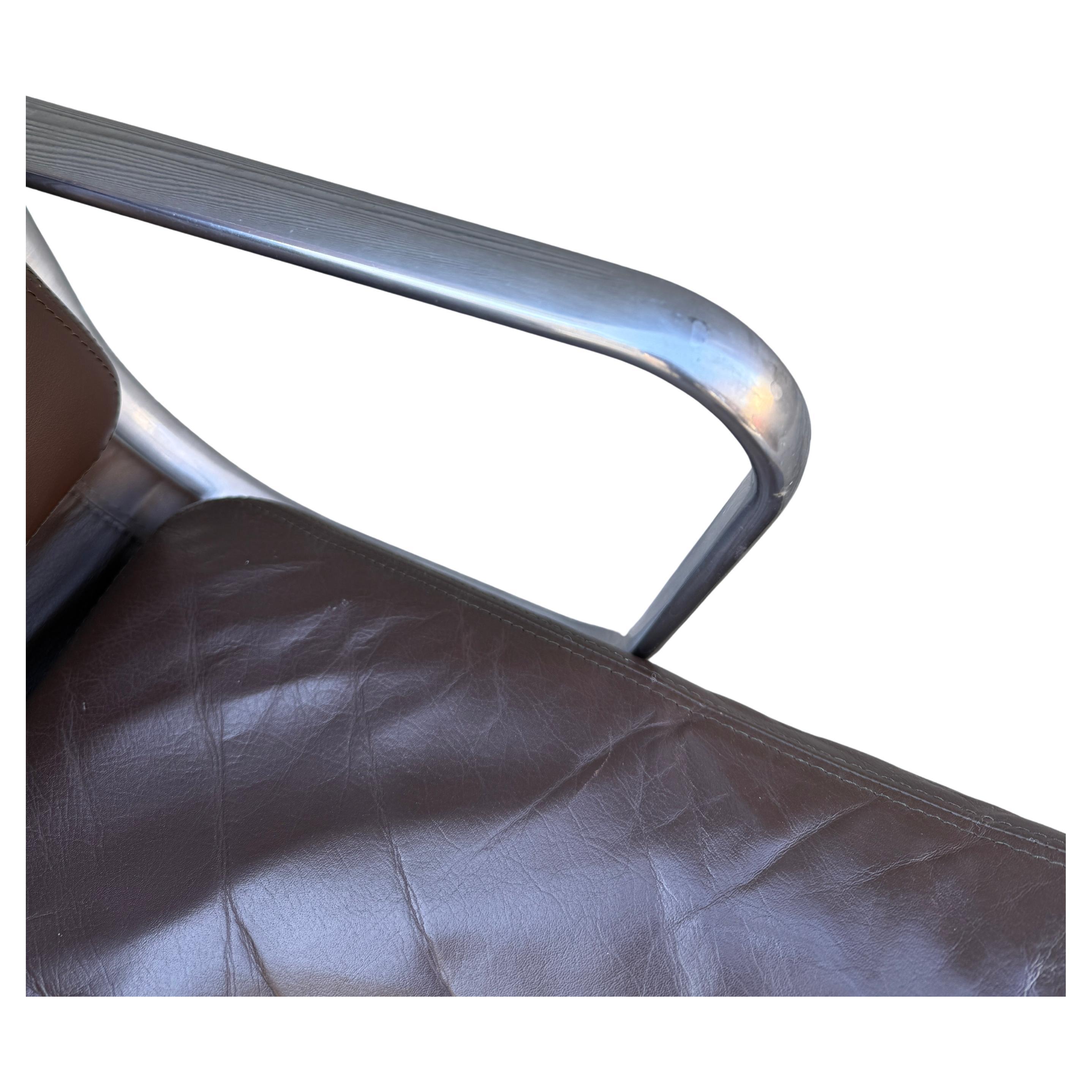 For your consideration is this authentic vintage Eames for Herman Miller vintage soft pad chair in brown leather circa 2000. Adjustable tilt and height with manual lift. These authentic examples are icons of Mid-Century Modern design. Eames aluminum