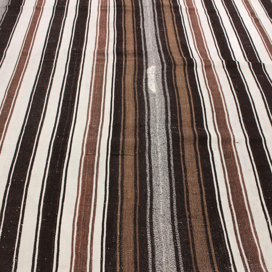 Handmade in Turkey, this vintage one-of-a-kind wool rug is made from goat hair. Perfectly imperfect, the medley of brown stripes and weaving have the beautiful depth from fibers that contemporary rugs simply cannot replicate. 

Our Turkish rugs are