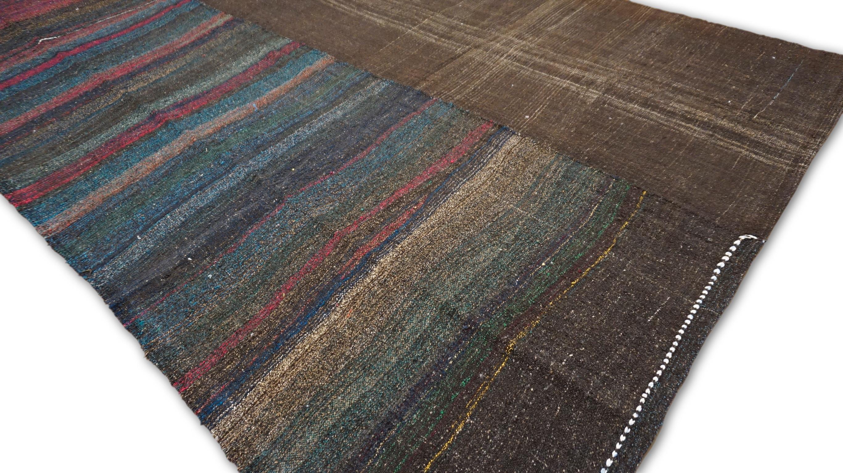 Dieser Kelimteppich aus Wolle im Vintage-Stil besticht durch sein horizontales Streifenmuster in kontrastierenden Rosa-, Grau-, Blau- und Brauntönen. Das kühne, lineare Design sorgt für einen auffälligen visuellen Effekt, der durch die leichten