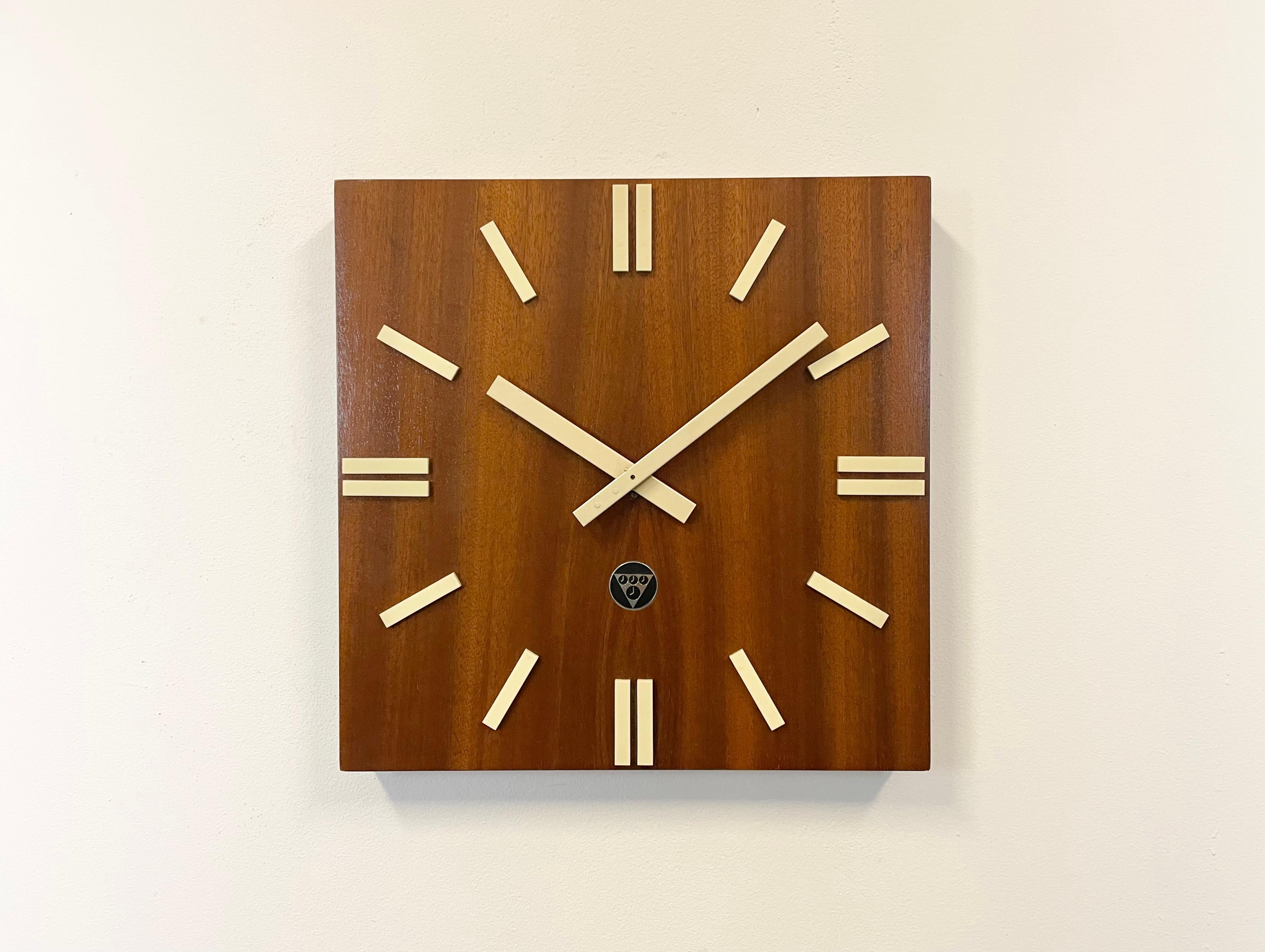 Wall clock, model PPH 410, produced by Pragotron in former Czechoslovakia during the 1980s. It features a brown wooden veneered clockface and plastic 5 minutes marks. The piece has been converted into a battery-powered clockwork and requires only