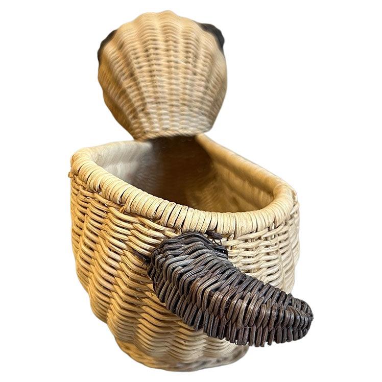 Una cesta vintage de mimbre tejida para cachorros de perro en color marrón. Esta bonita cesta quedará genial como regalo para un baby shower, expuesta en una estantería o incluso utilizada como cesta de fruta en una mesa de desayuno. La cesta es