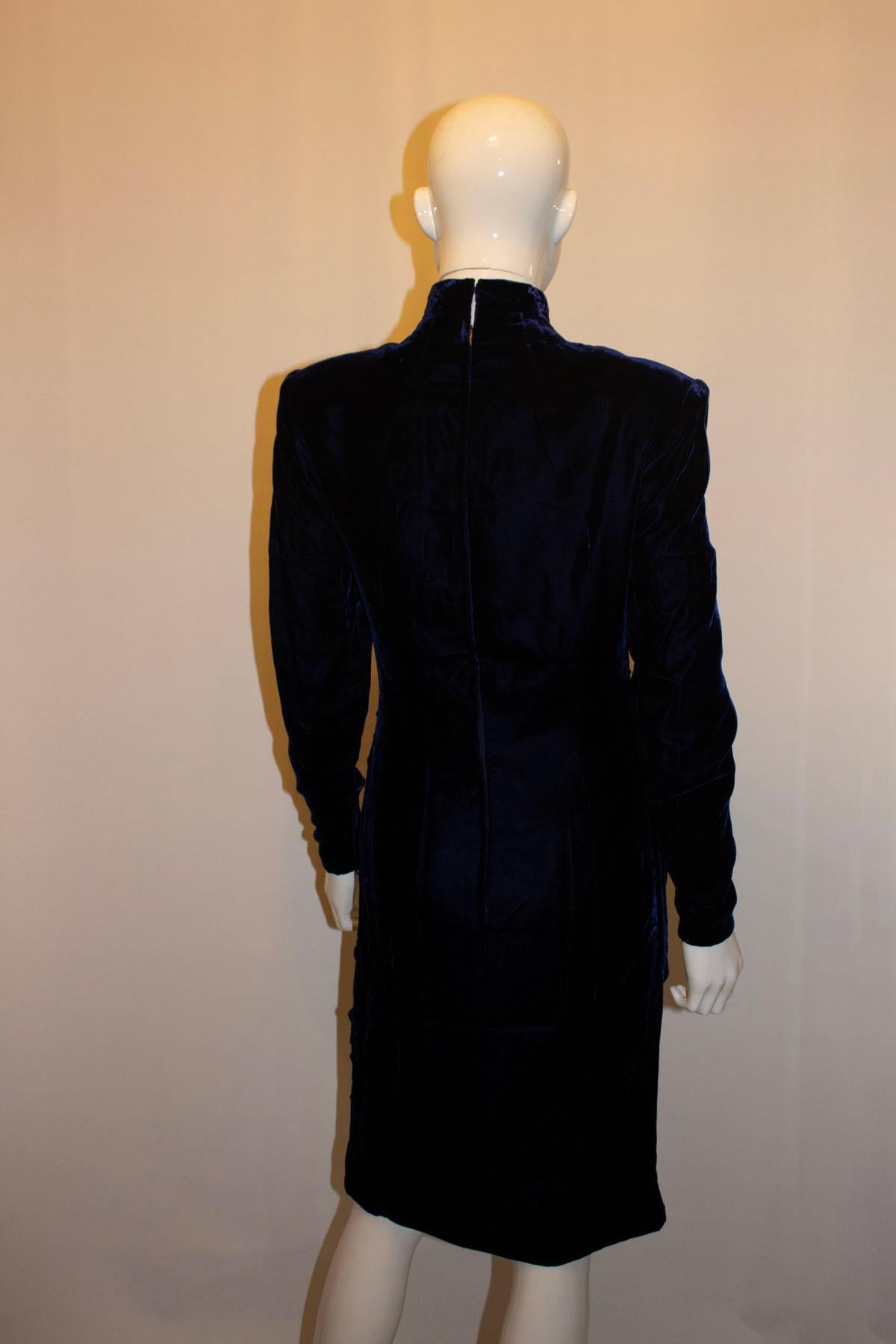 A fun and easy to wear vintage party dress by British designer Bruce Oldfield. In a blue velvet, the dress has pleat detail on the front,  a stand up collar , back central zip and zip sleaves. It is unlined, and has the original shoulder pads which