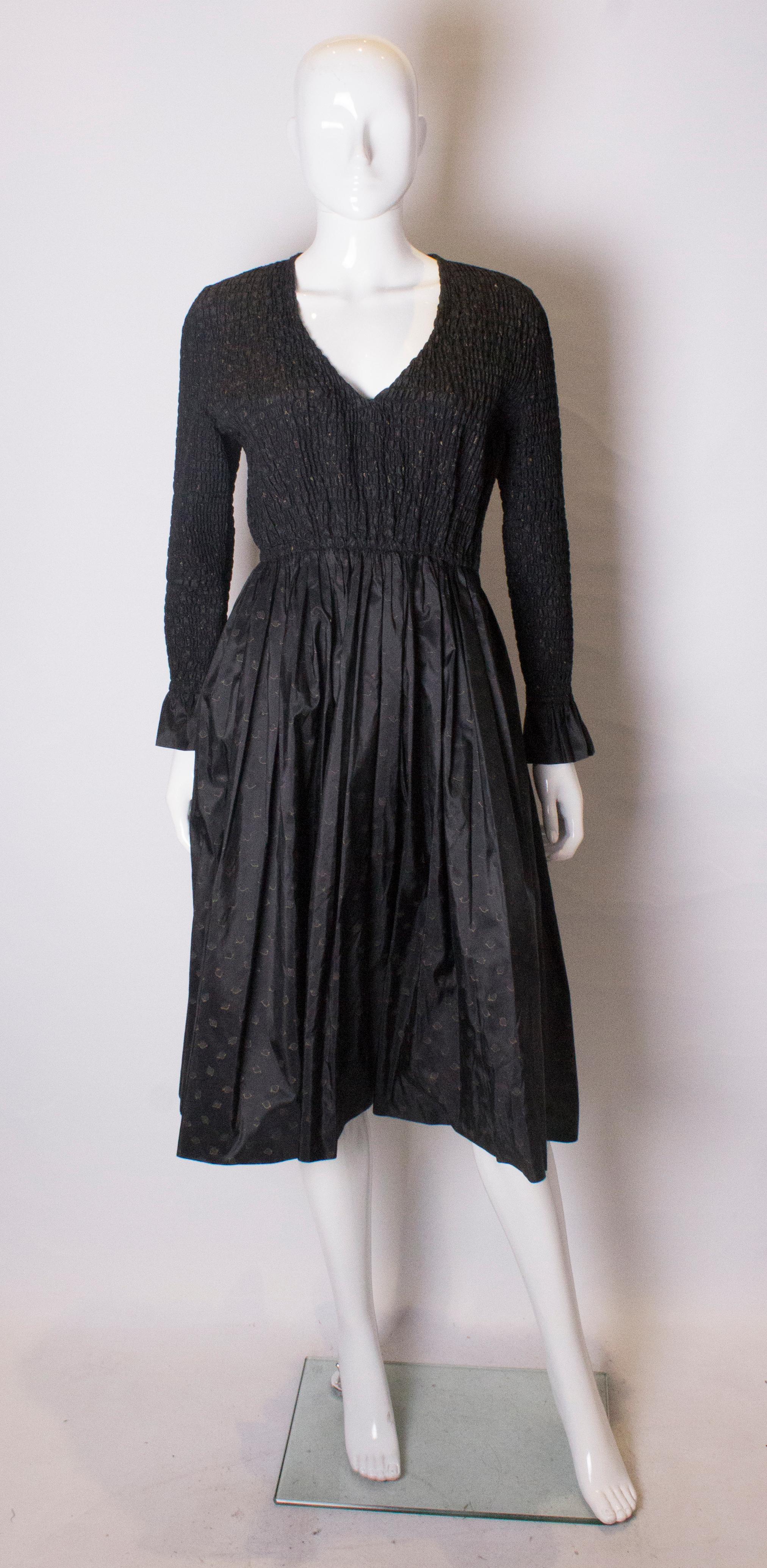 A chic vintage silk dress by Bruce Oldfield.  The dress has a gathered bodice is rooching and a v neckline. The skirt has an attractive spade design, and it has a side zip opening.