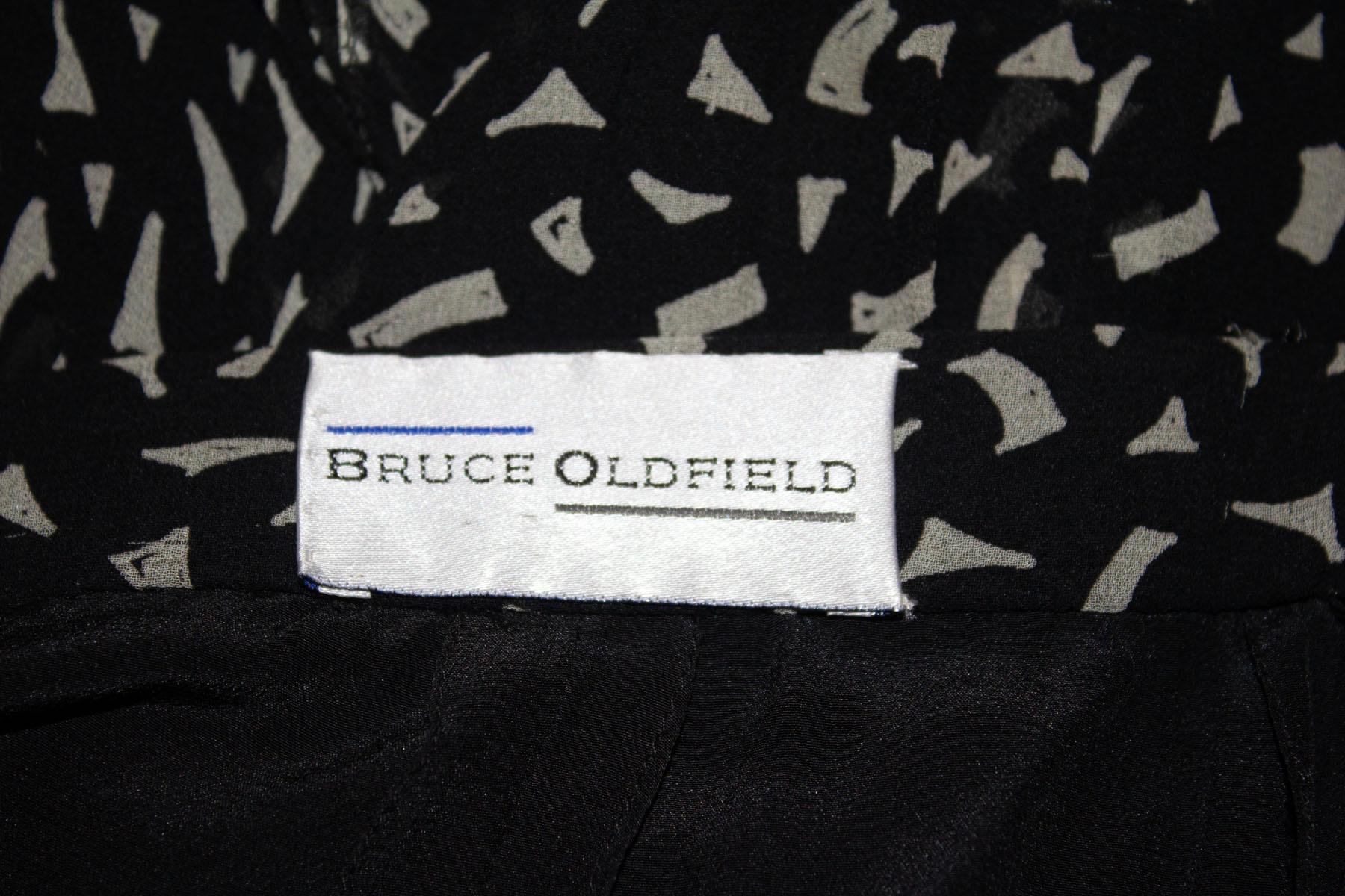 Ein wunderschöner Vintage-Seidenrock von Bruce Oldfield.
Der Rock hat einen abstrakten schwarz-weißen Druck, eine tolle Schnittführung und eine Rüsche am Rücken. Sie ist vollständig gefüttert und hat einen zentralen Reißverschluss auf der
