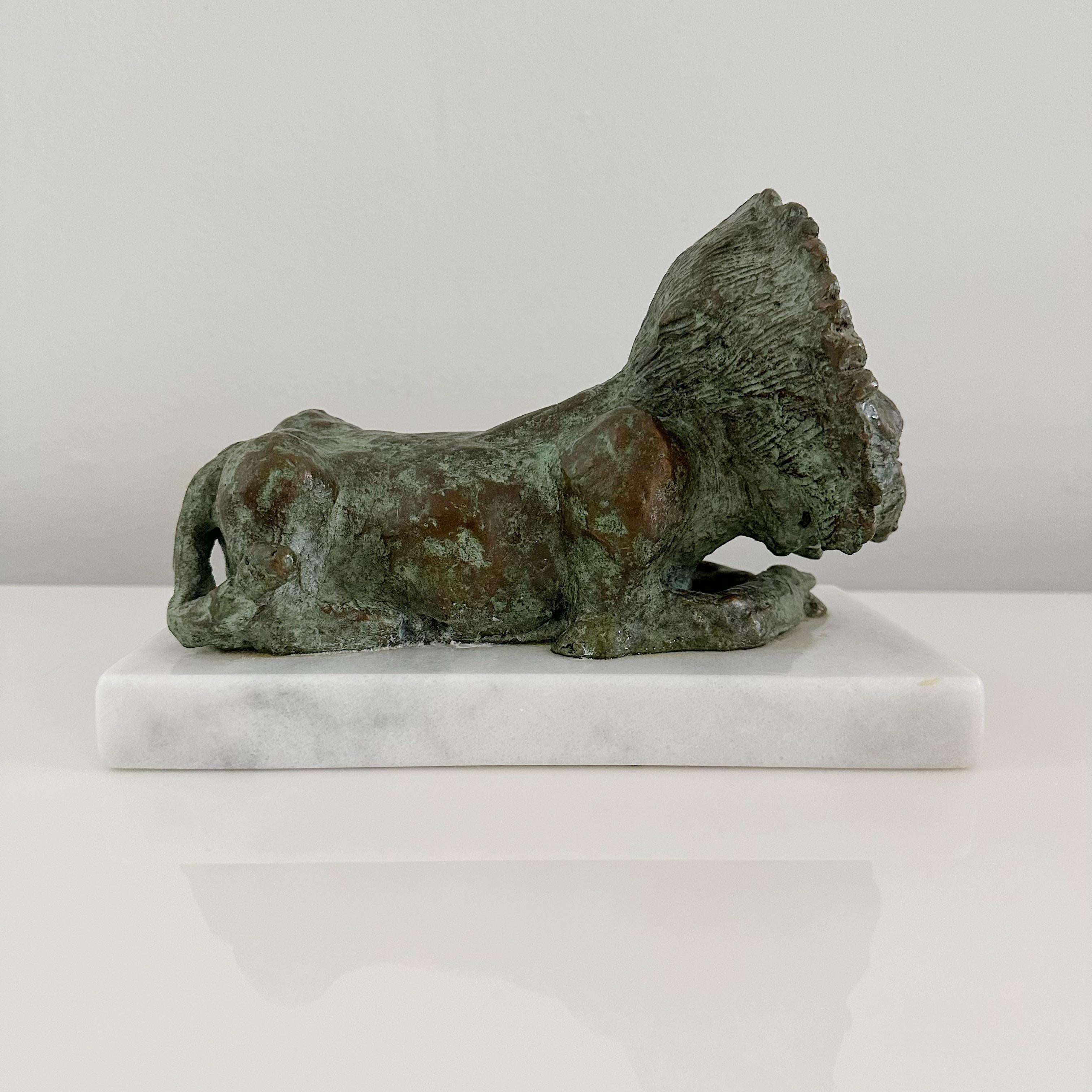 Mid 20th century brutalist bronze reclining lion on white Carrera marble base. Glue marks can be seen where lion is attached to the marble base. Signed, illegible signature. This bronze shows a loverly warm patina.