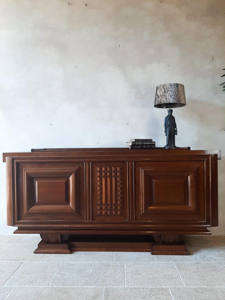 Vintage design sideboard by Charles Dudouyt in oak, 1940s-50s. Beautiful sideboard in pre-Brutalist Art Deco style decorated with typical geometric shapes of Dudouyt. The base gives this sideboard an extra sturdy character.

Dimensions: H 110 x W