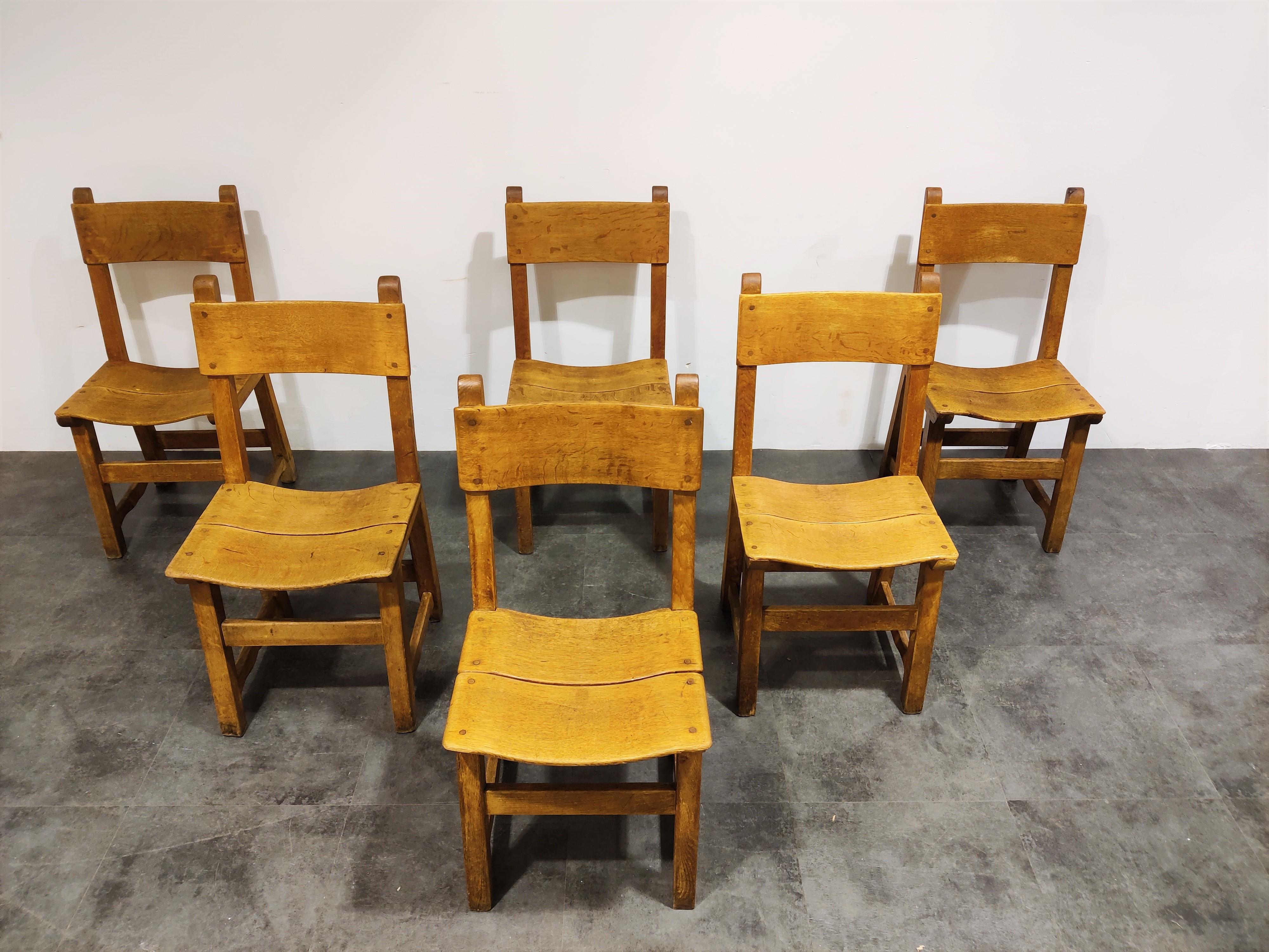 Rustic oak dining chairs with a brut design.

Slightly curved seat and backrest panels.

Good condition with normal age related wear.

Nice and sturdy.

1960s - France

Dimensions:
Height: 92cm/36.22