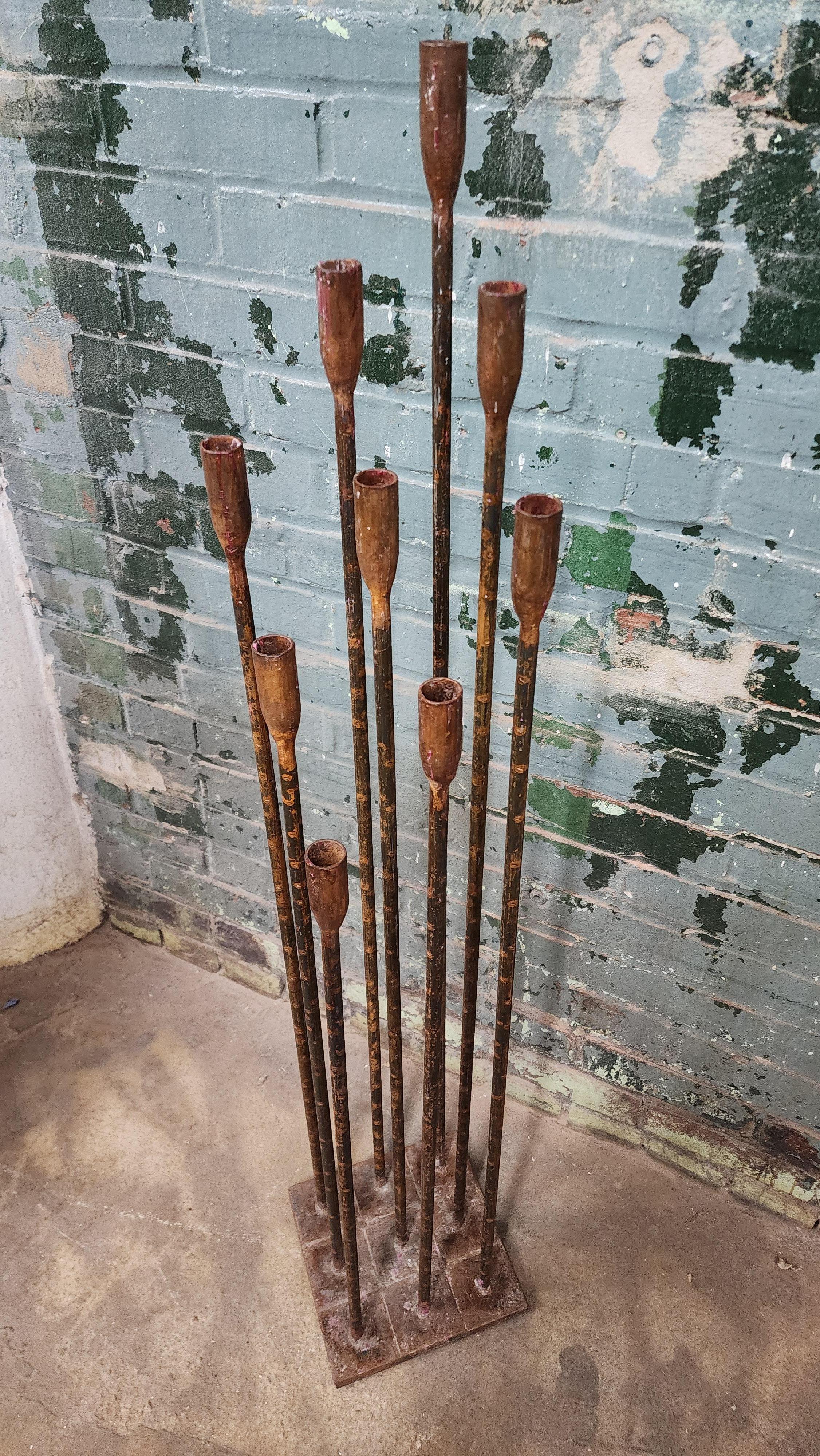 Beautiful iron floor candelabra in the manner of Harry Bertoia. Holds 9 candles and stands about 4 ft tall. Has a cool patina with melted wax.