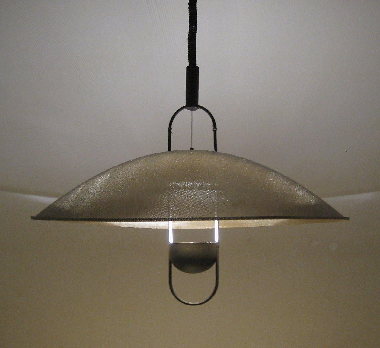 Monumental metal Macumba pendant by Örni Halloween manufactured in Italy by Artemide in the 1970s. The elegant metal cup at the reflector bounces light up and through the over-lying sieve-like aluminum hat, creating a dazzling yet meditative