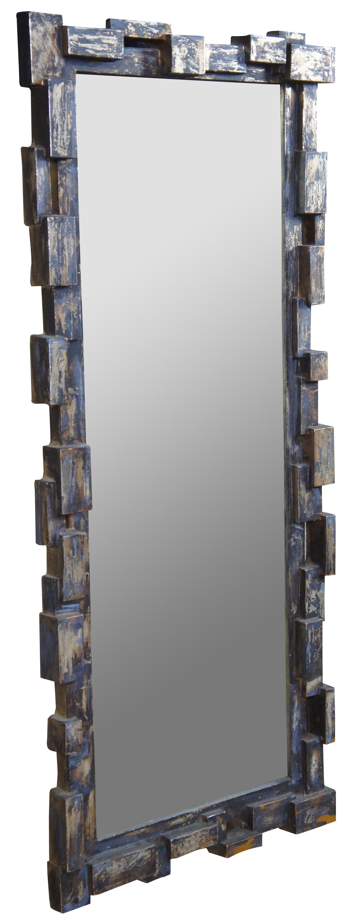 Brutalist inspired wall mirror. Features a black and gold distressed finish. Measures: 41”.
  