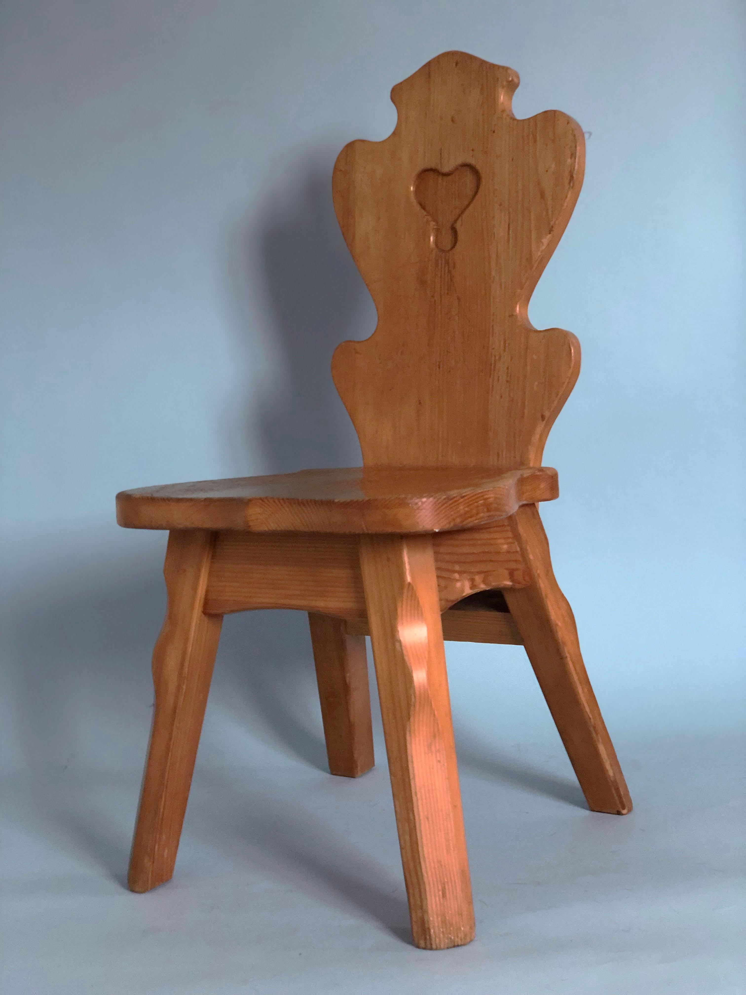 Mid Century Scandinavian dining chairs from Sweden, 1960s. The seat and back are shaped for a good sitting position. A heart is cut in the back. Very thick, angular design typical of the brutalist aesthetic. They are made from solid pine and are