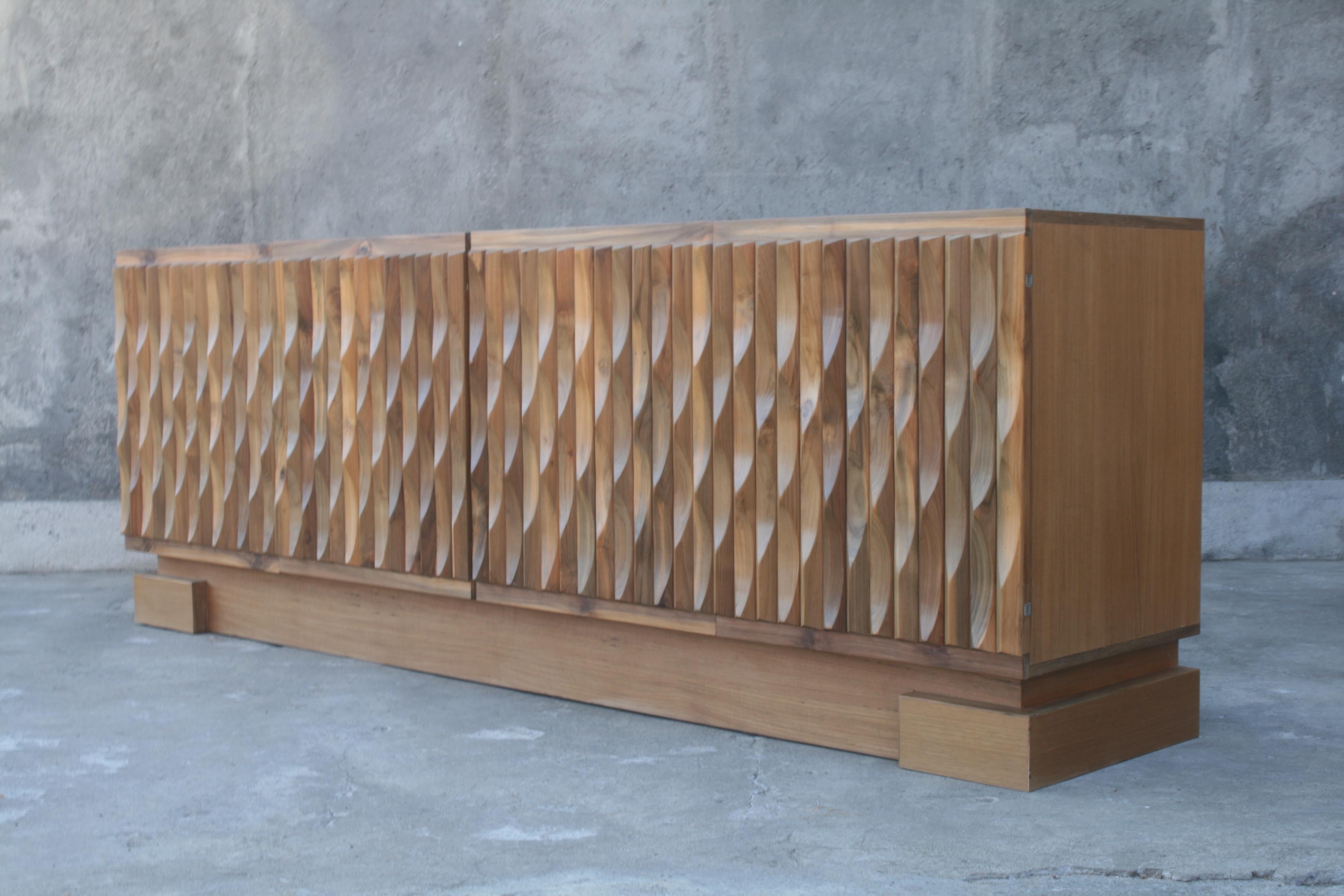 This sculptural sideboard has solid wooden graphic panels. We cleaned and stripped the doors completely and finished them with a natural oil. This cabinet looks fantastic, with only minor wear. Italian Prameta hinges. Made in Belgium by De