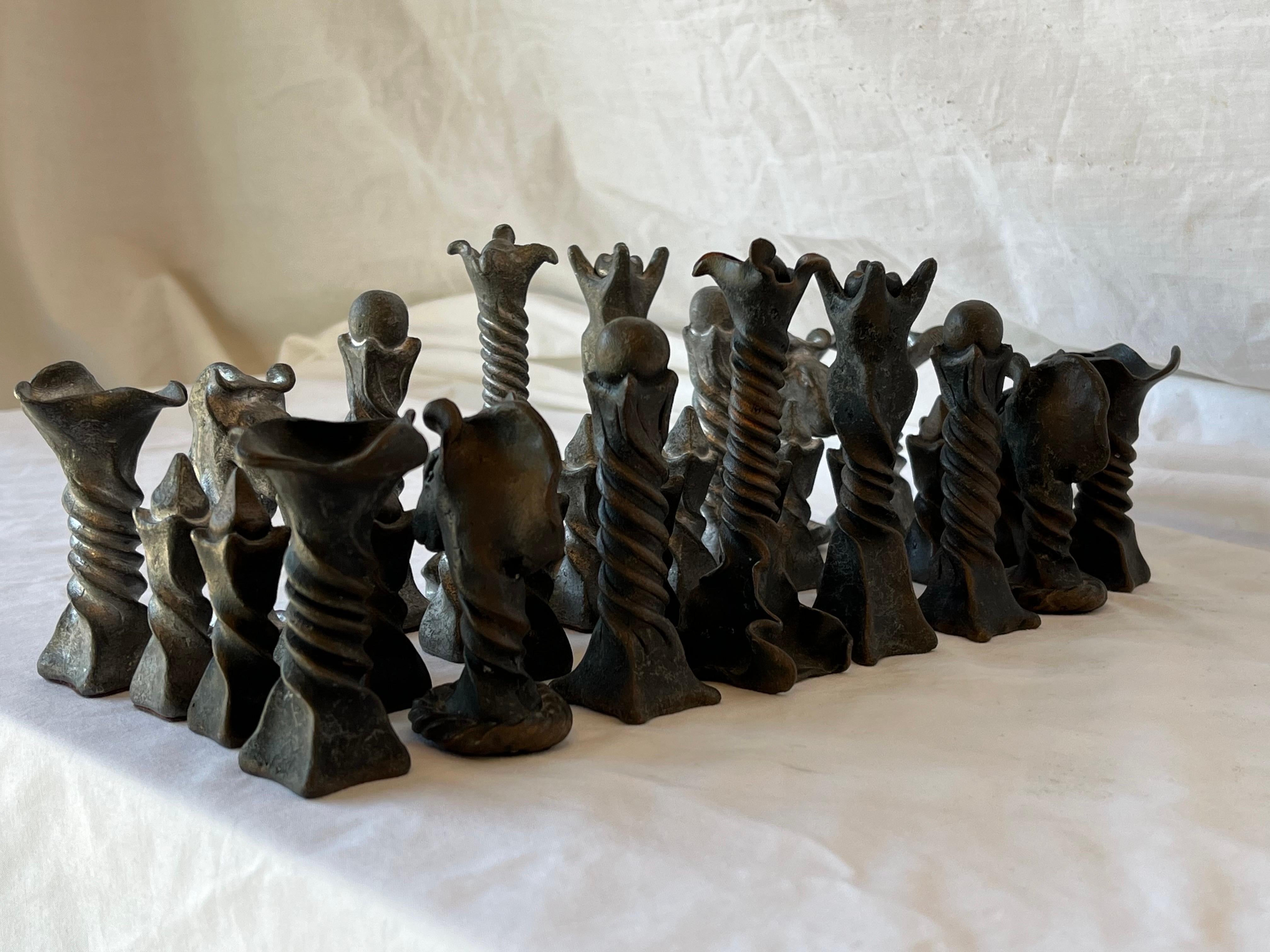 A vintage Brutalist style chess set in cast metal. The pieces feature a twisted and flanged design. Brutalism is a design movement characterized by form and texture - this set has both in spades. The twisted shafts of the pieces evoke movement while