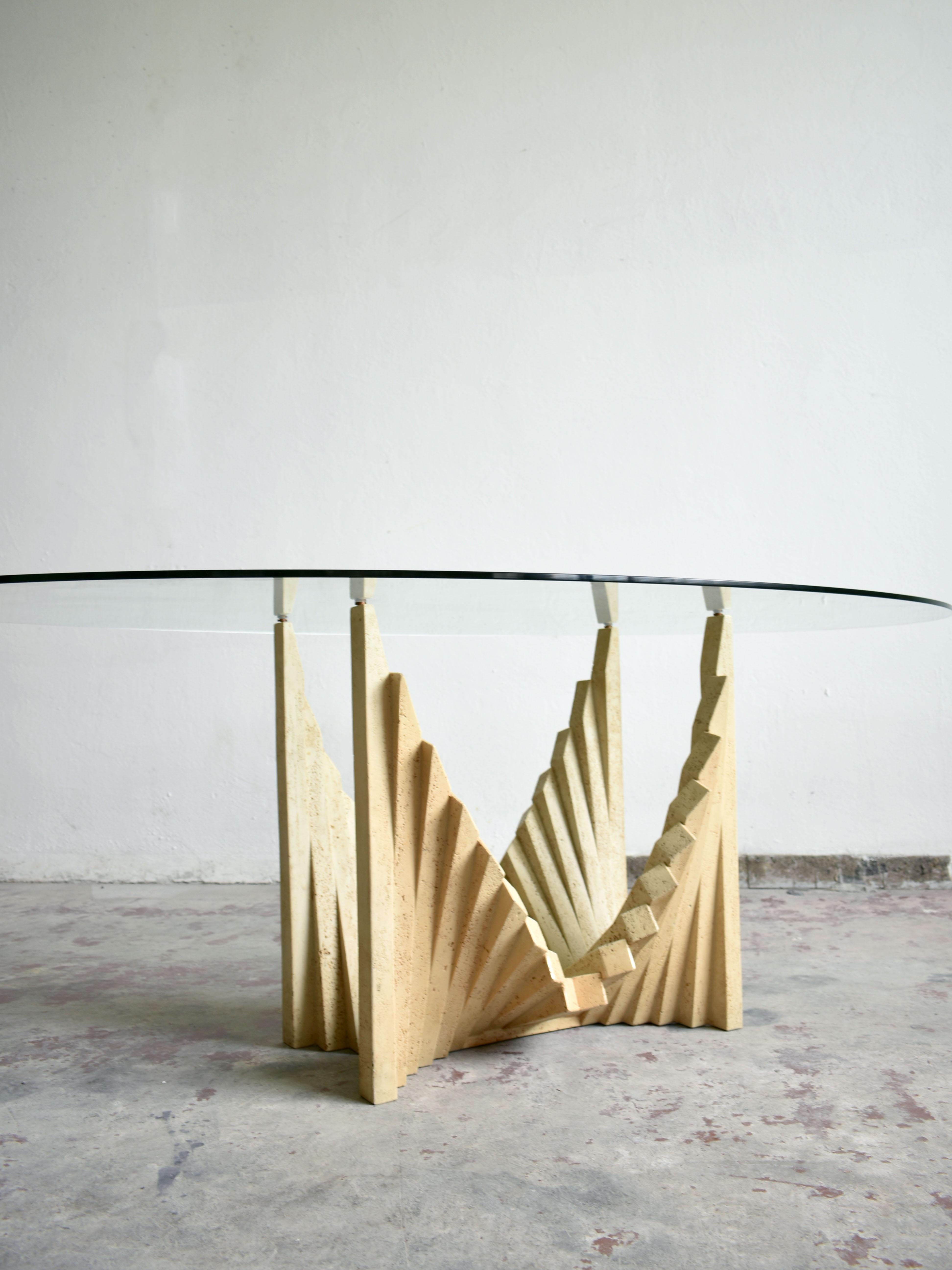 Brutalist sculptural dining table with oval-shaped clear glass top that rests on top of a travertine base, France, 1970s.

 