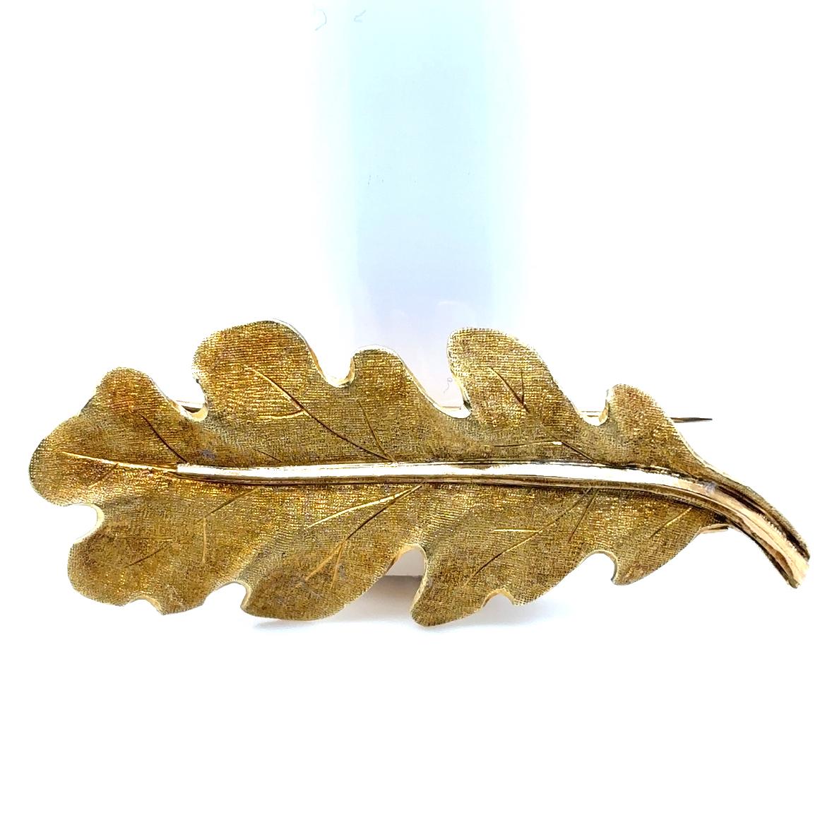 A vintage Buccellati 18 karat yellow gold oak leaf brooch, circa 1960

Designed as a single 18 karat yellow gold oak leaf.
Buccellati's signature gold detail engraving contrasts to the plain polished stem running along the centre of the leaf.

The