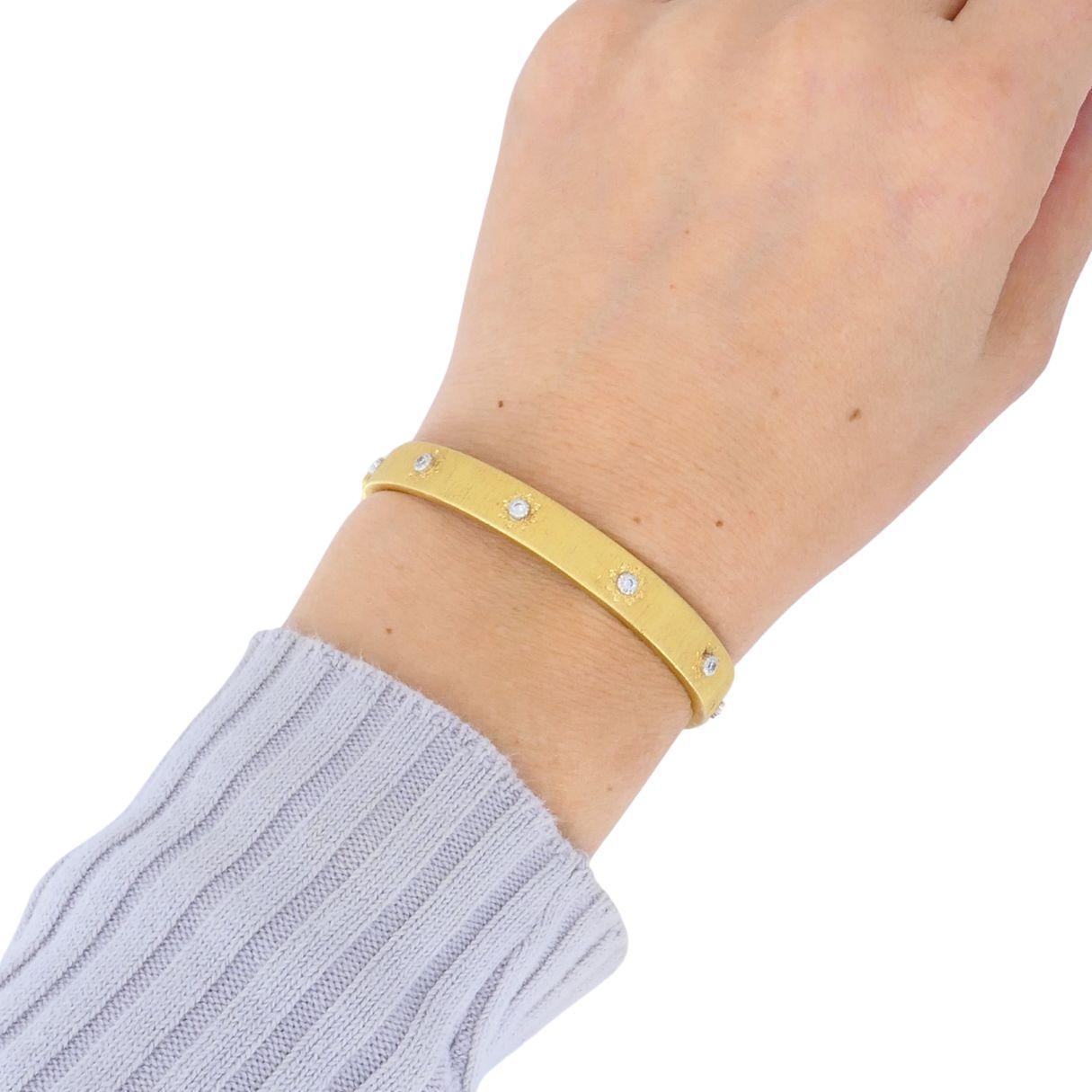 Esta elegante pulsera brazalete vintage Buccellati encarna el arte característico de la casa y su sofisticación atemporal. Fabricada a mano en oro amarillo de 18 quilates, la pulsera presenta un acabado rigato -una fina textura grabada a mano que