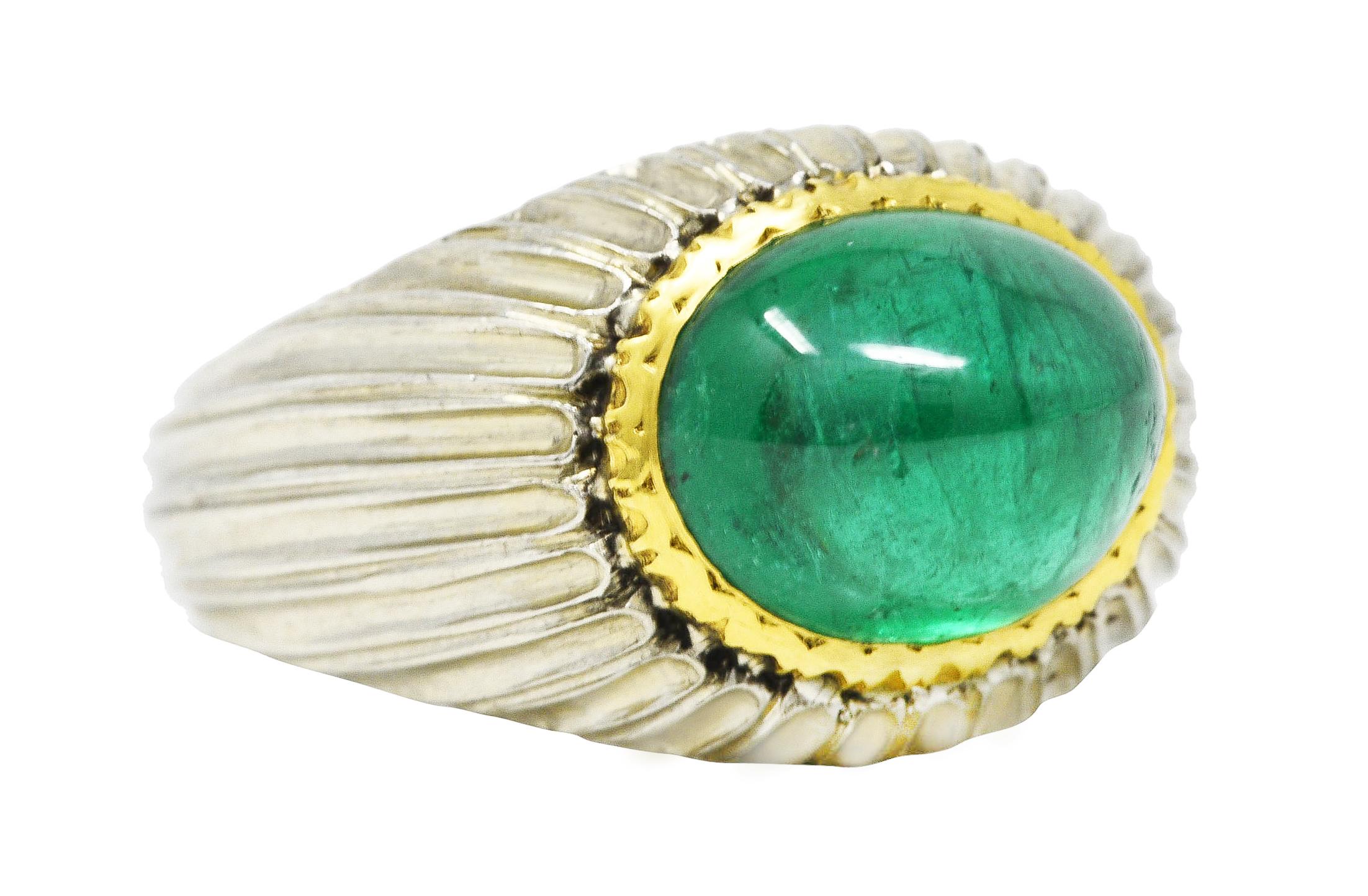 Bombè band ring is highly rendered with a deeply fluted texture. While centering an oval cut emerald double cabochon weighing approximately 4.83 carats. Very strongly bluish green in color and semi-transparent with natural inclusions. Bezel set in a
